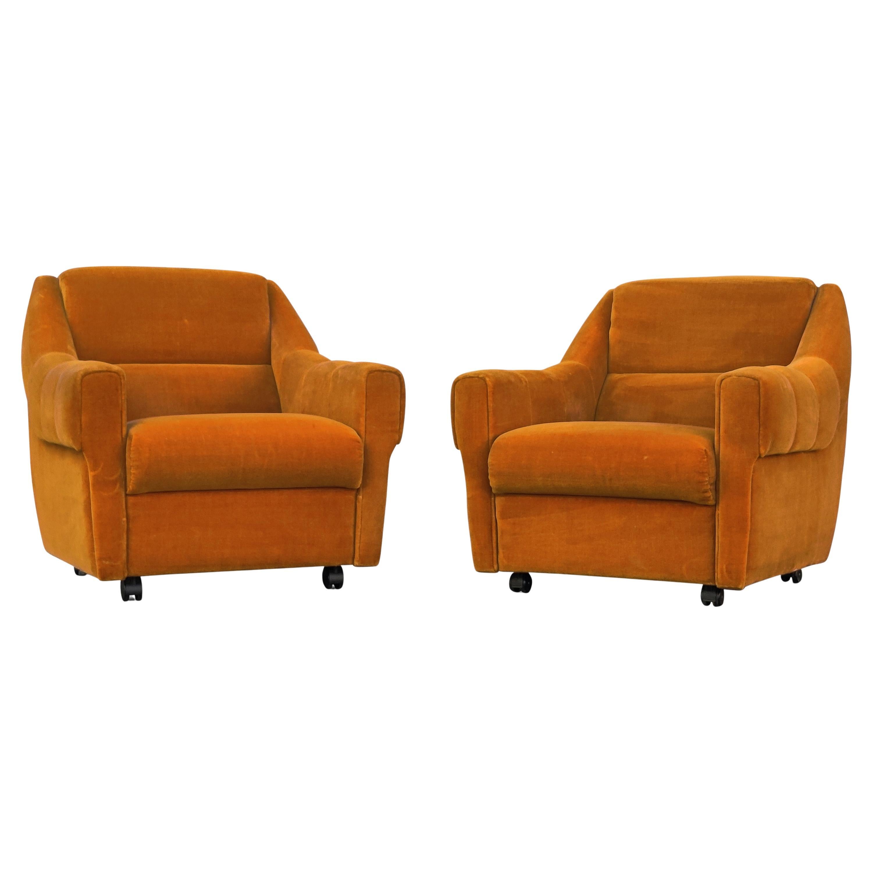 A low slung pair of orange upholstered lounge or club chairs, made in Denmark over 50 years ago, and have aged like fine wine! The construction is very strong and makes for a great seating experience. The cushions are soft and supple and mold to