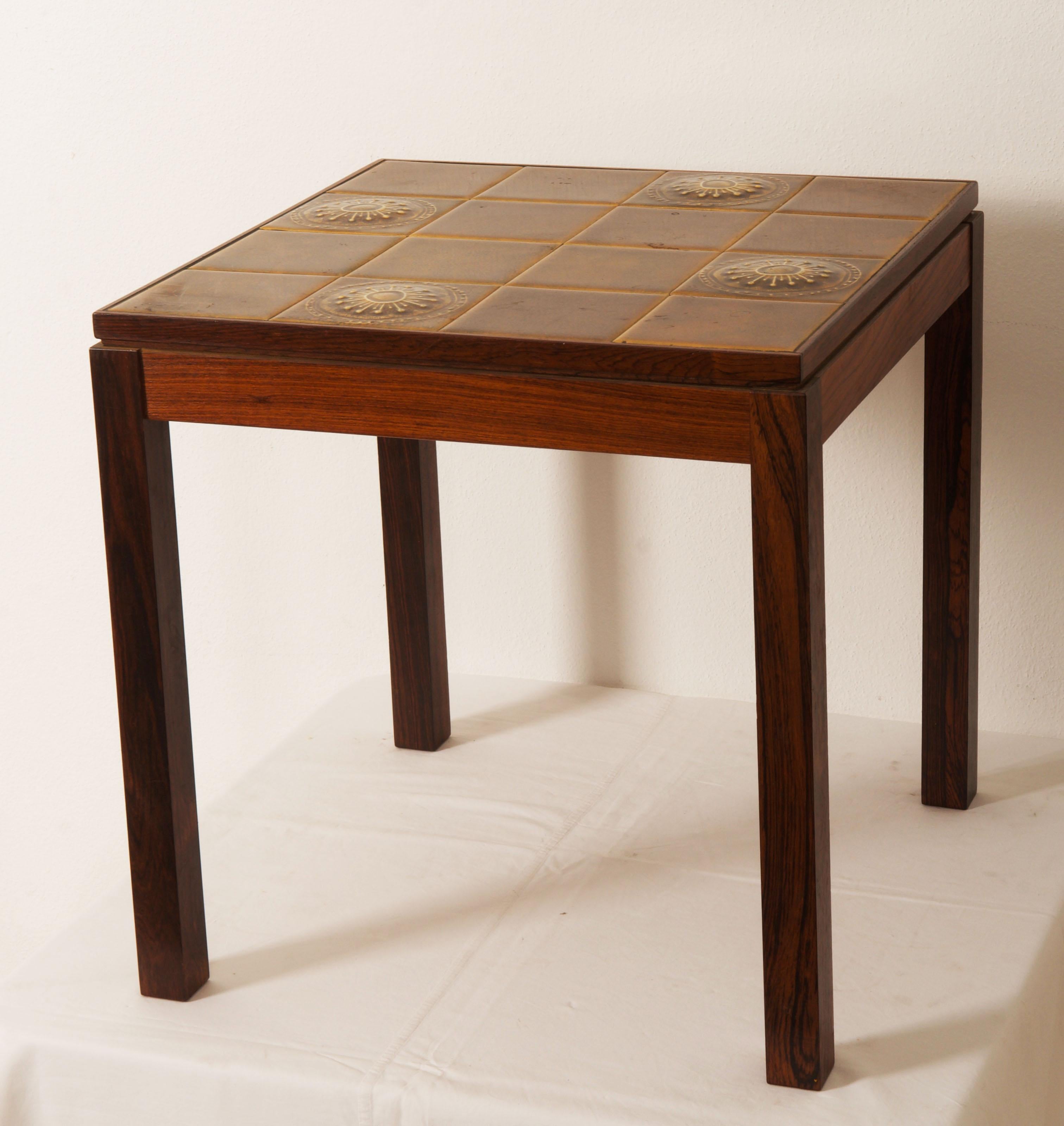 A pair of hardwood tables with a decorative tiled top. Made in Denmark in the 1960s.