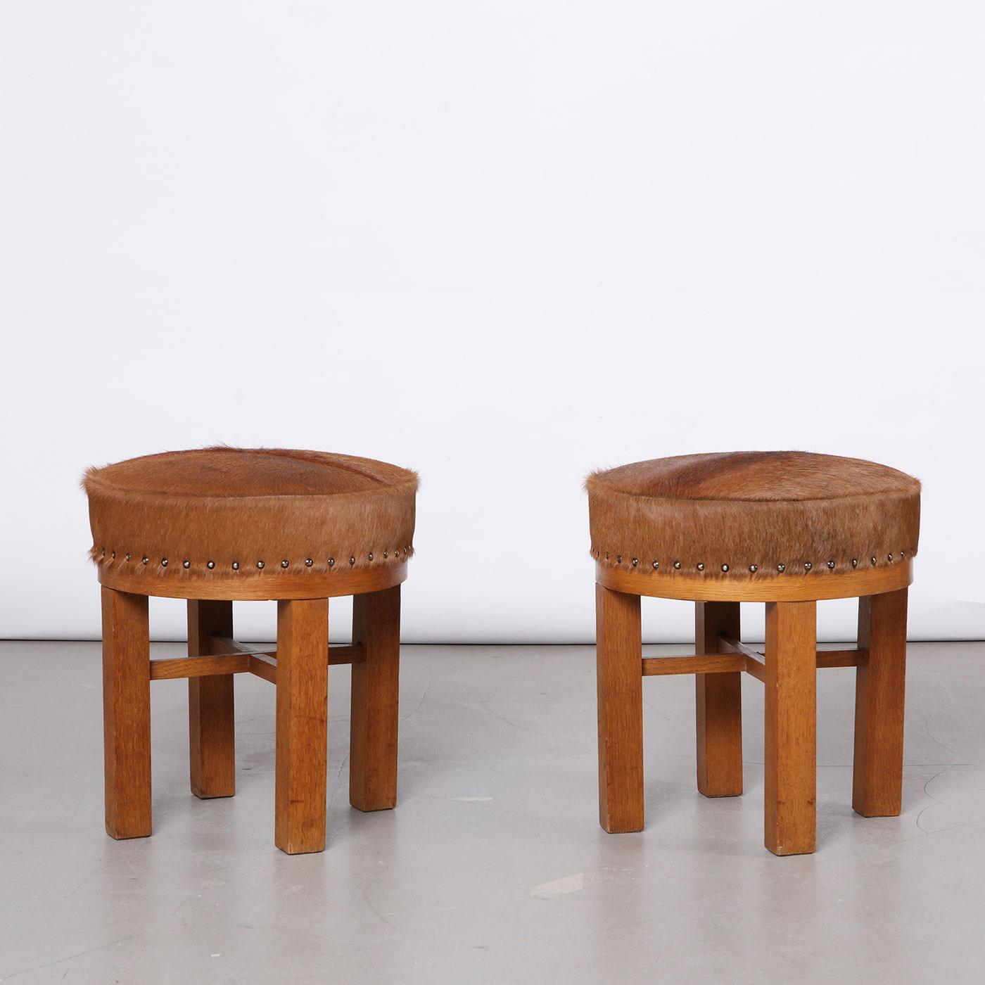 Pair of Danish stools, tabourets, ottomans, made by a Danish cabinetmaker in the 1940s. Made from wood, seats are newly upholstered in cowhide with metal tacks around the frame.

Dimensions:
Height: 43 cm / 16.93 in
Diameter: 40 cm / 15.75 in