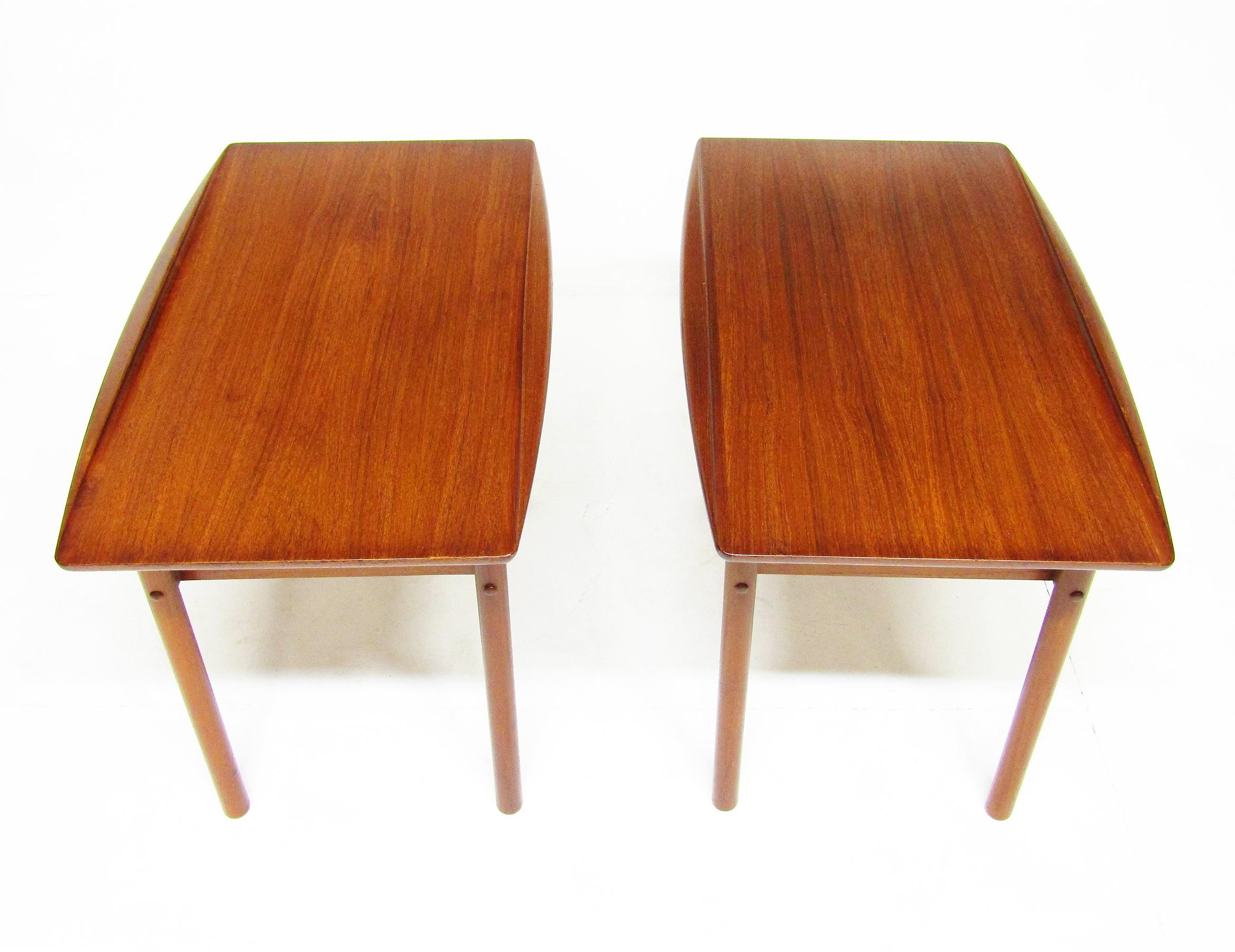 A pair of beautifully sculpted side tables in teak by Grete Jalk for P. Jeppesen.

These 1960s surfboard-style tables feature gracefully curved edges and slatted shelf undertiers.

They are in excellent, refinished condition, retaining the warm,