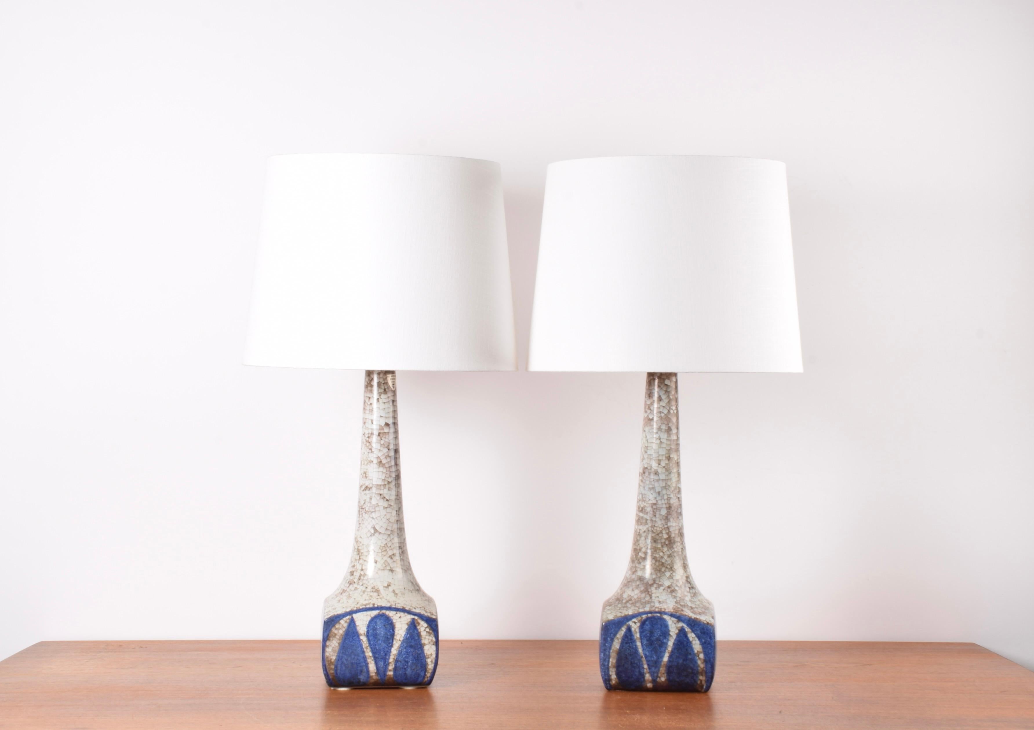Pair of tall ceramic table lamps designed by Marianne Starck for the Danish ceramic workshop Michael Andersen & Søn (MA&S) on the Danish island Bornholm. Made ca 1960s.

The lampbase shows a stylised leaf or flower decor in blue and gray. The glaze