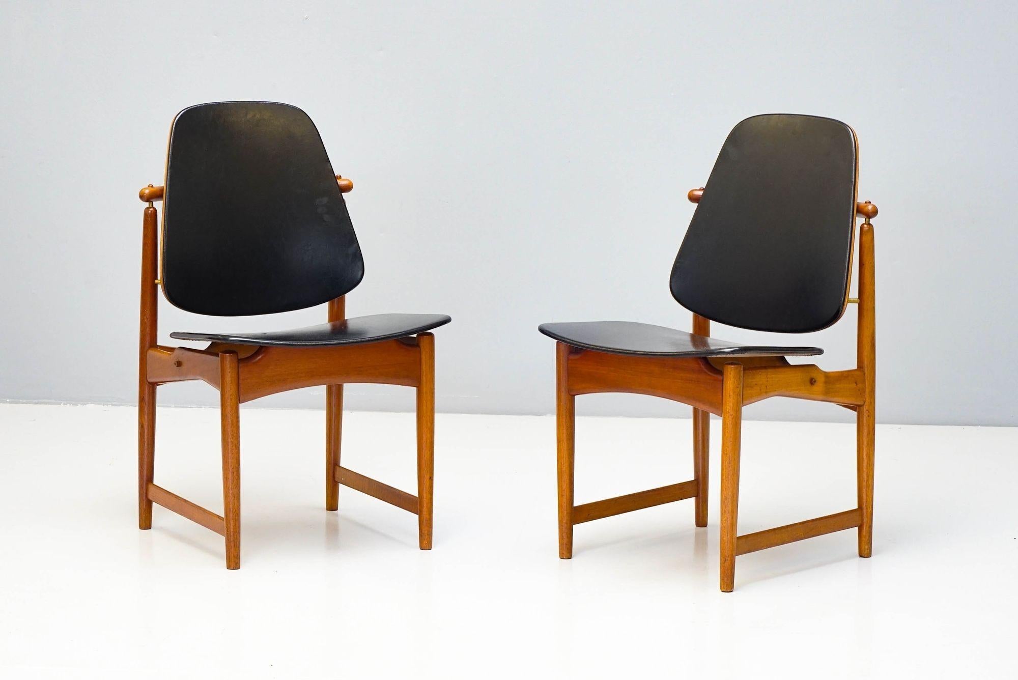 Coppia di sedie danesi in teak e pelle di Arne Vodder per France & Daverkosen. Telaio in teak massiccio con sedili e schienali originali in pelle con dettagli in ottone che tengono in posizione lo schienale. Un piccolo foro su un pad del sedile,