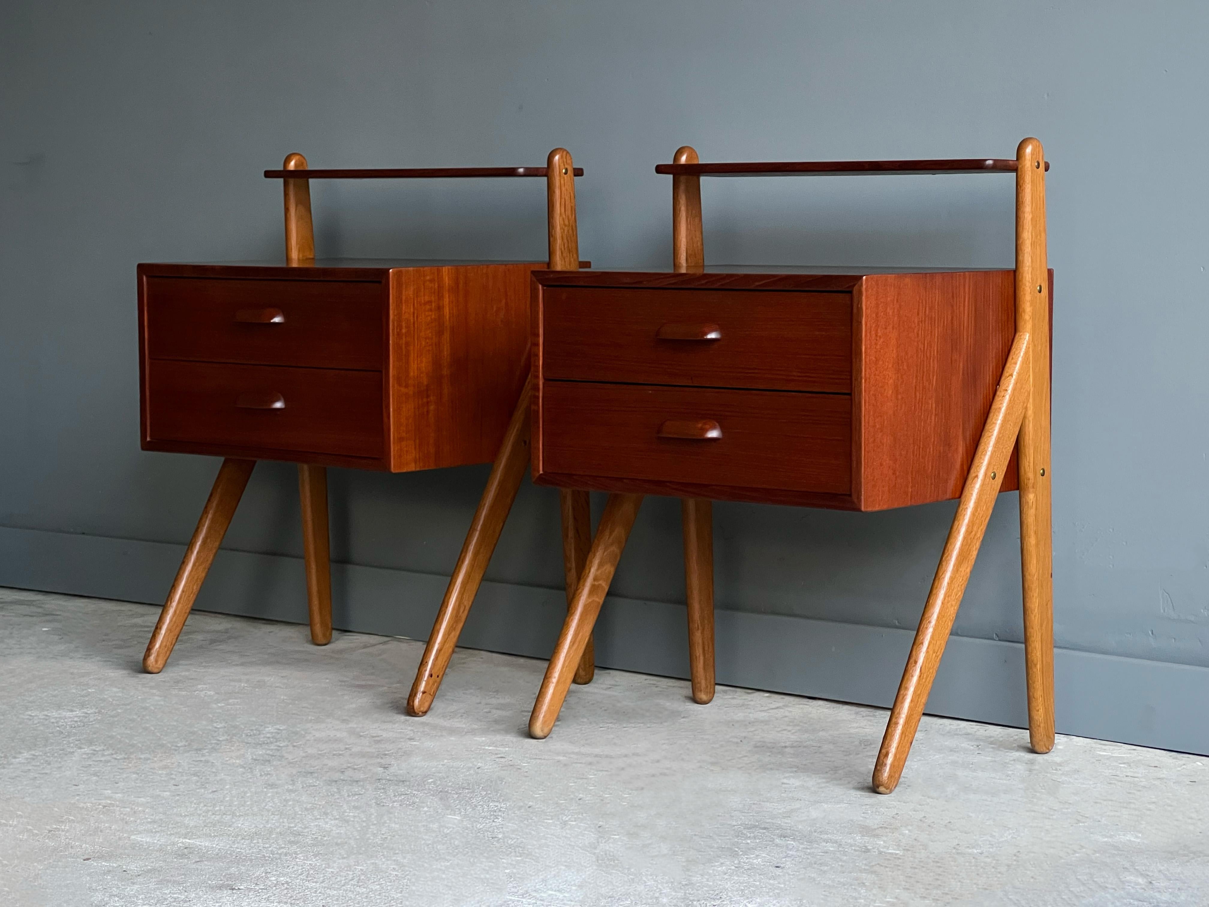 Petite pair of Danish nightstands or end tables designed by Sigfred Omann and produced by Olholm Møbelfabrik. Circa, early 1960s. 

Constructed of teak drawer boxes, solid teak upper shelves and beautiful grained oak legs with brass hardware. We