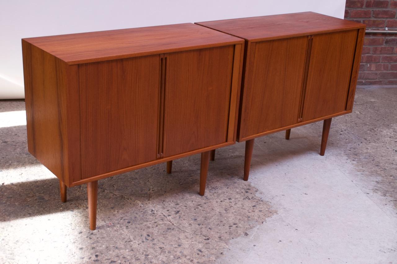 Pair of stylish and compact teak cabinets designed in the 1960s by Kai Kristiansen for Feldballes Møbelfabrik of Denmark.
The two tambour doors with elongated, recessed pulls open to reveal open storage flanked by a removable shelf (one / cabinet).