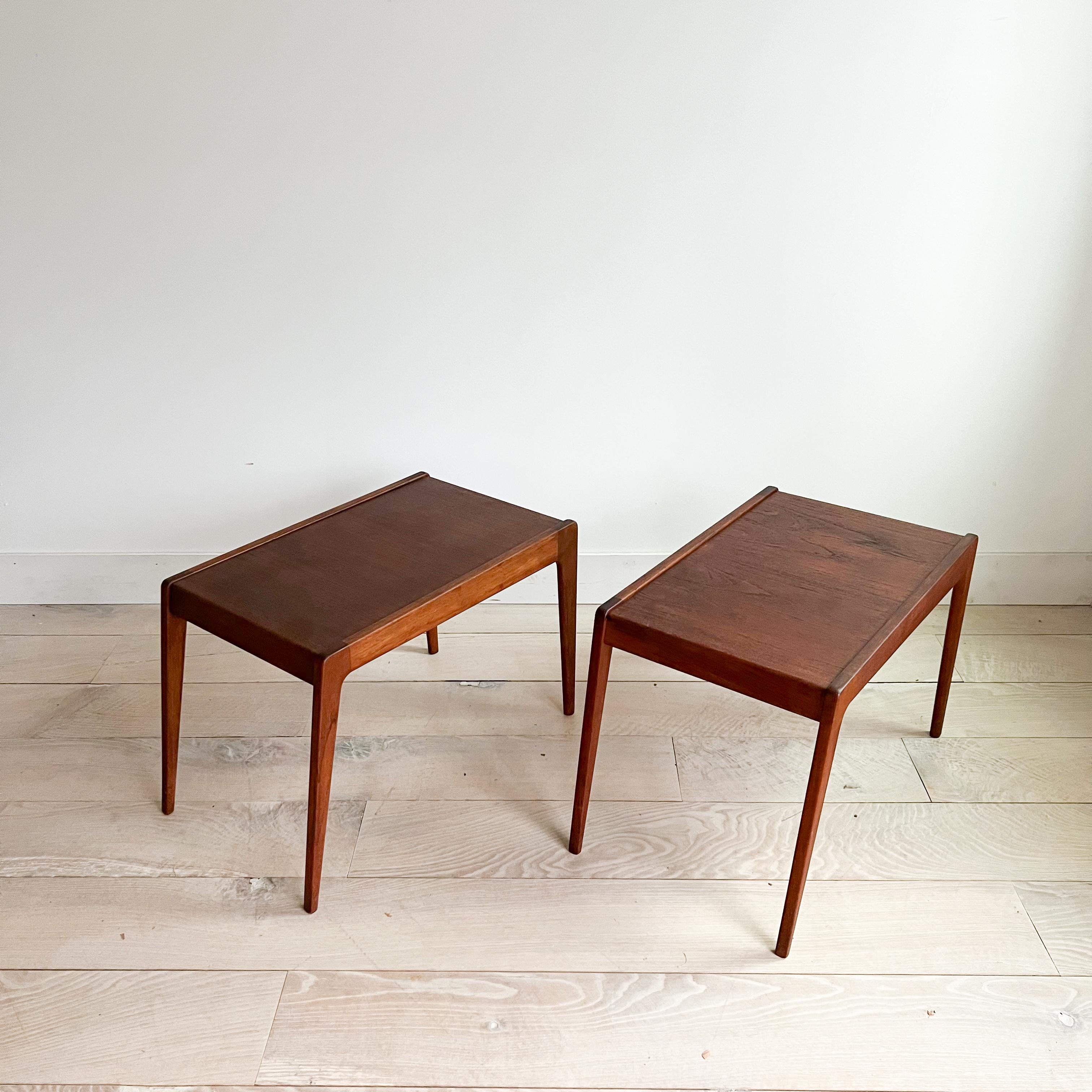 Presenting a pair of mid-century modern Danish teak end tables crafted by Kurt Ostervig for Jason Mobler. These timeless pieces, measuring 16.5 inches by 25.75 inches, stand at a practical height of 18 inches.

Boasting the classic teak aesthetic,
