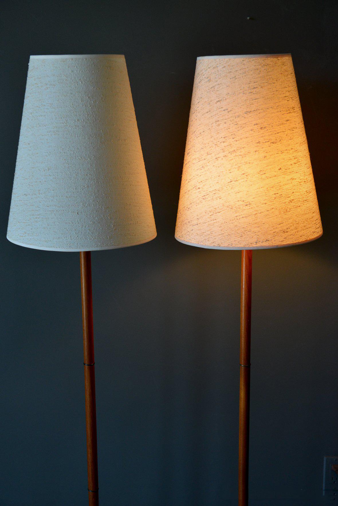 Pair of Danish teak floor lamps with original shades, circa 1960. Beautiful teak bases with brass ring inserts on the neck. Original wiring and original linen shades in excellent condition.

Lamps measure 62.5