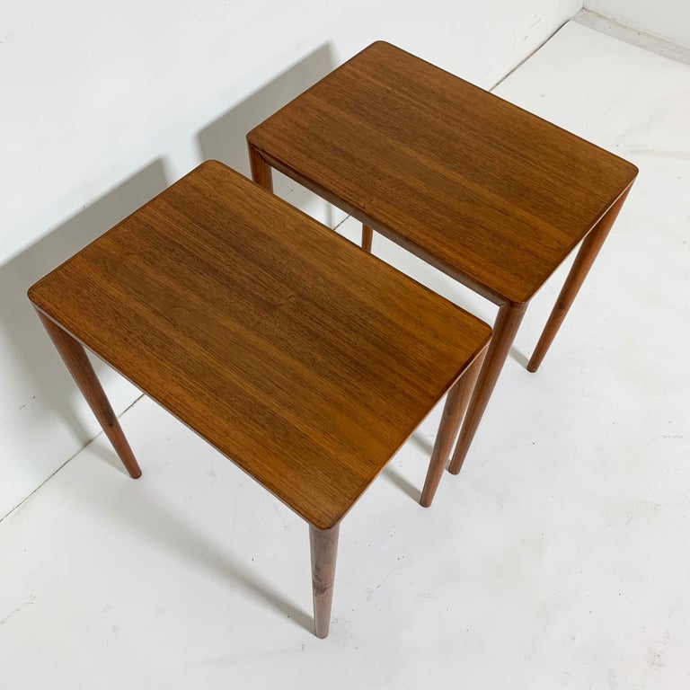 Pair of Mid-Century Modern Danish teak lamp tables, circa 1970s. Gracefully slender and thin edged tops make these an elegantly Minimalist pair.