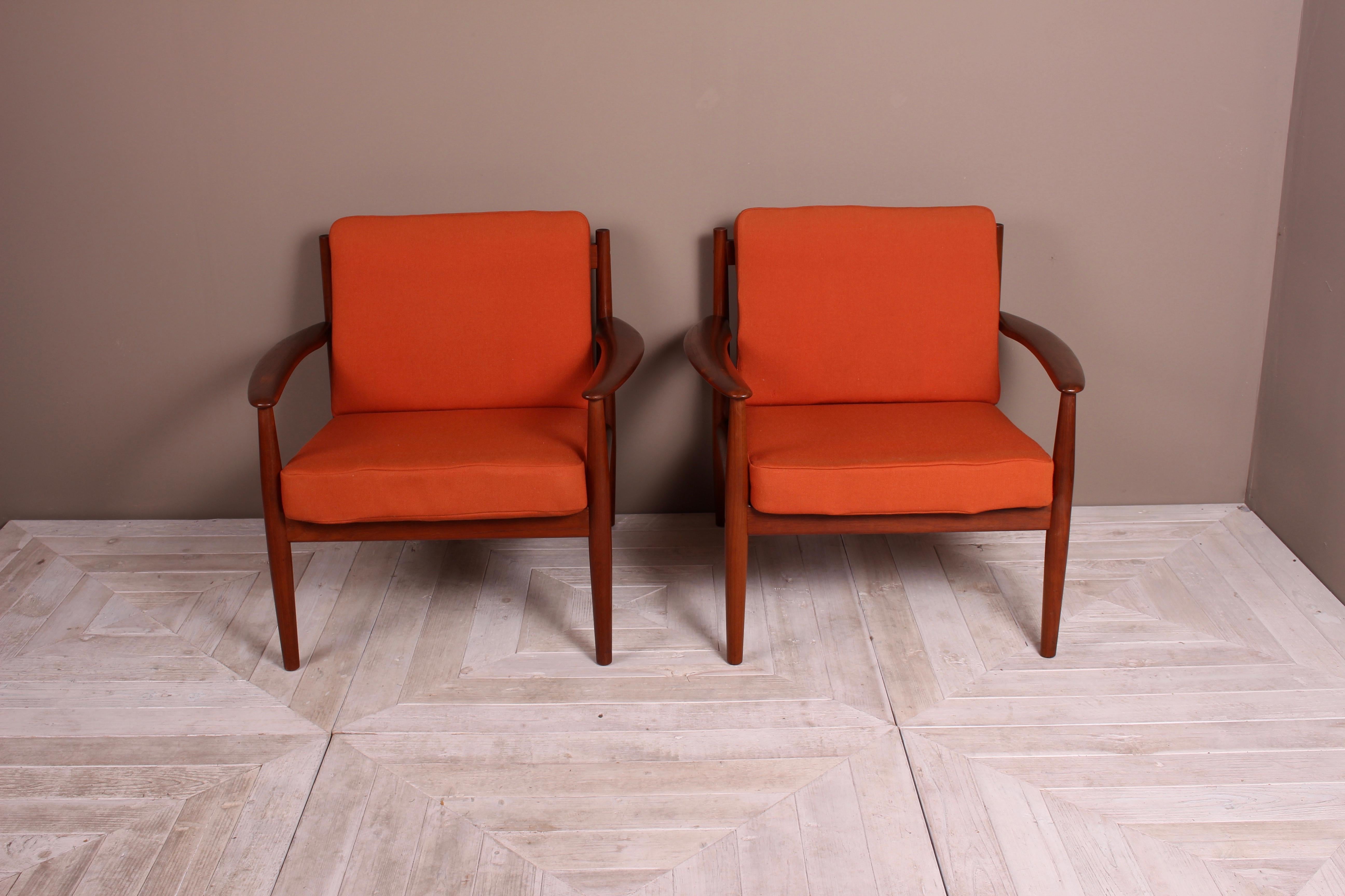 A beautiful pair of Danish teak lounge chairs by Grete Jalk for France & Son. The Danish modern design with original innerspring cushions and covered in a nice burnt orange fabric. Produced by France & Son, Denmark. We like to keep our items as