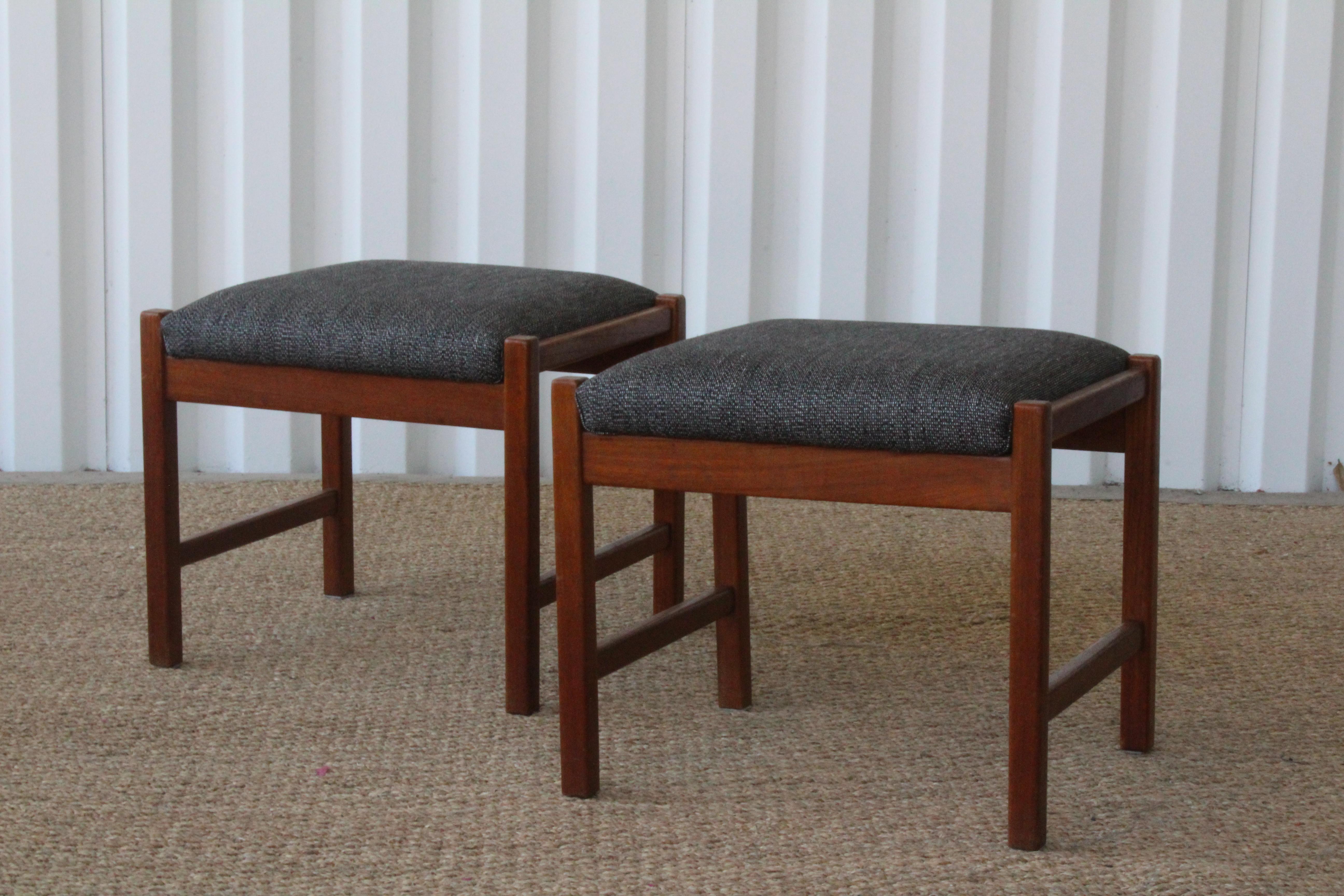 Pair of midcentury Danish modern stools in teak. New grey woven linen upholstery. Both are in excellent condition. Sold as a pair.
