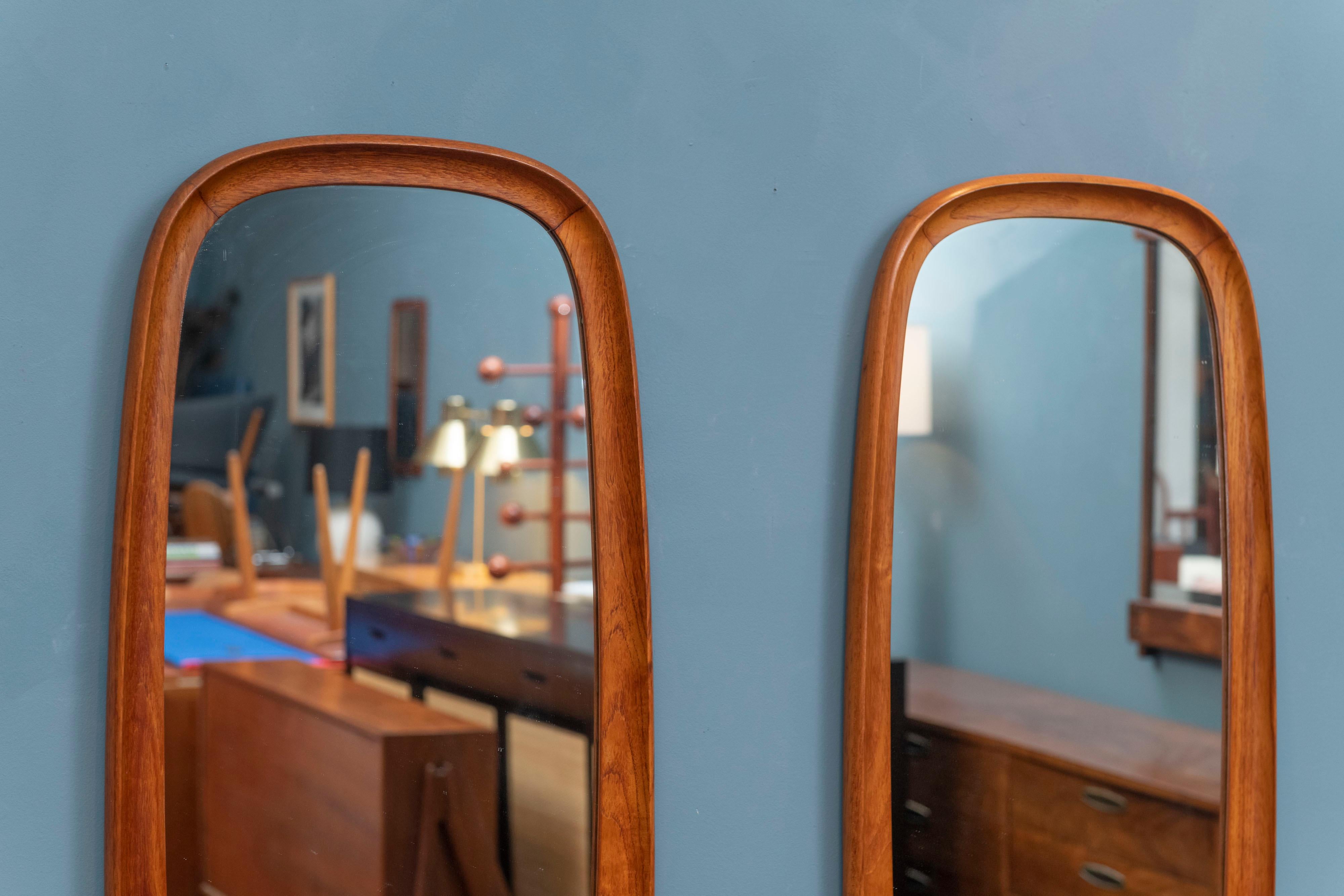 Pair of Scandinavian Modern teak wall mirrors, Denmark. Interesting sculpted oval form mirrors that are rare to find in pairs, ready to be enjoyed.