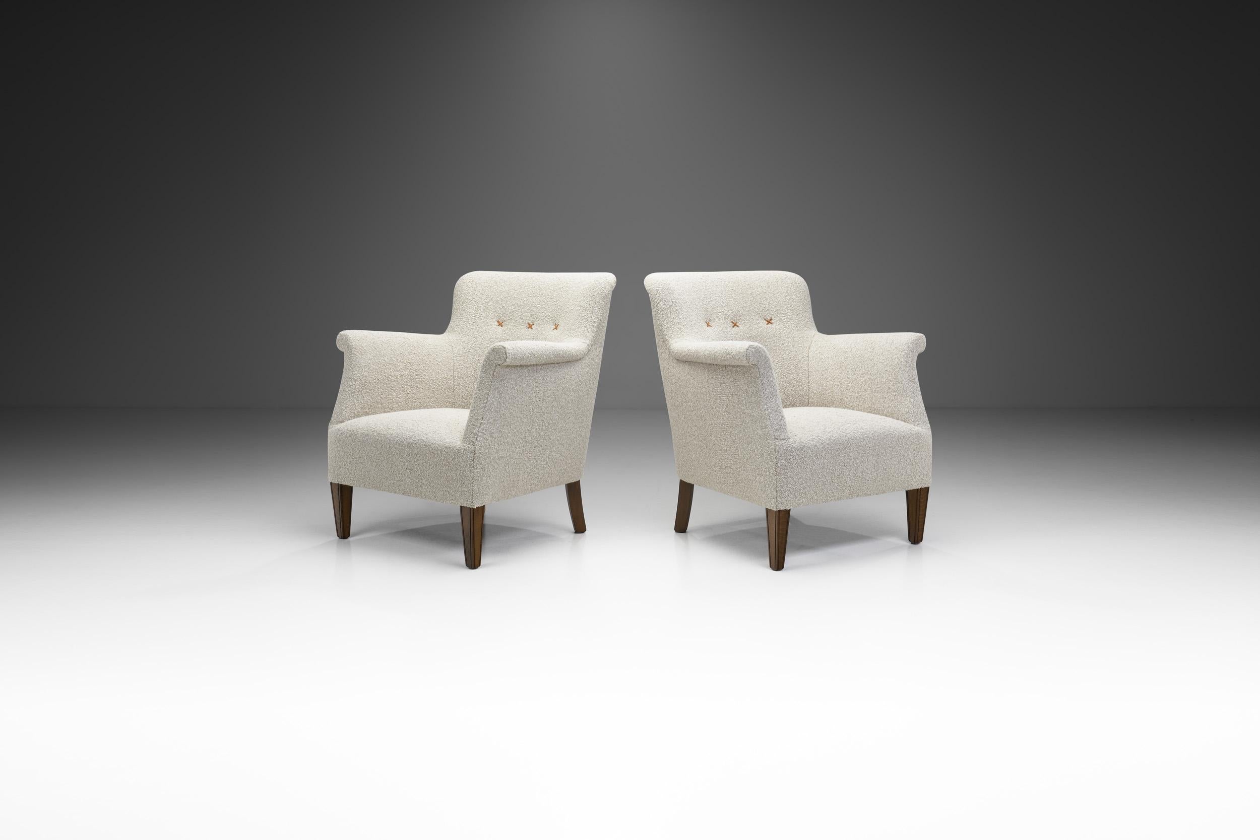 Cette paire de fauteuils de fabrication danoise est caractérisée par les meilleures qualités du design danois du milieu du siècle. De l'esthétique sobre à l'association élégante des matériaux, ces modèles rembourrés sont les parfaits exemples de la