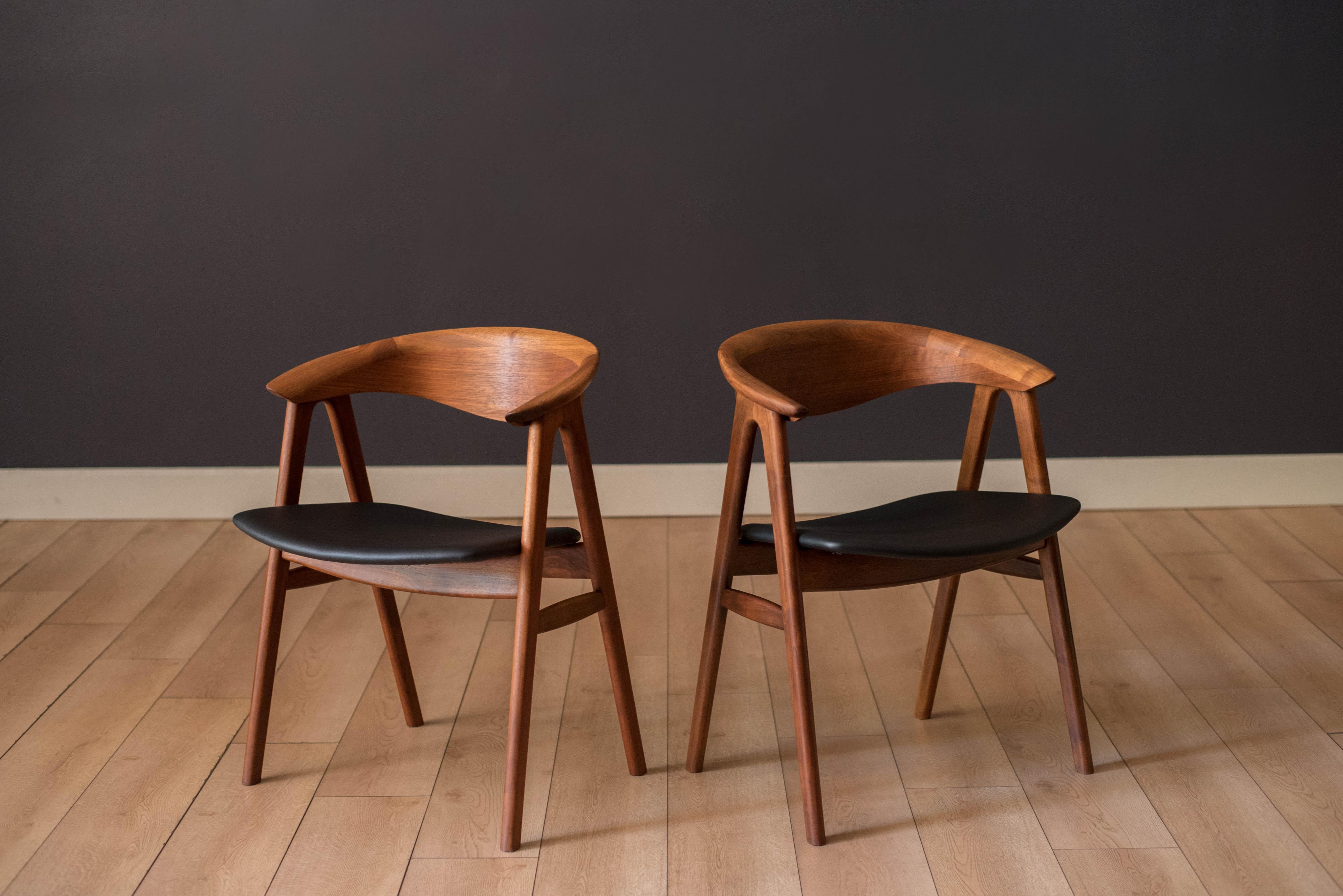 Pair of Mid Century Modern Compass dining chairs in walnut designed by Erik Kirkegaard for Hong Stølefabrik, Denmark model no. 52 imported by Dux. This  side chair set features sculpted backrests and the seats have been newly reupholstered in black
