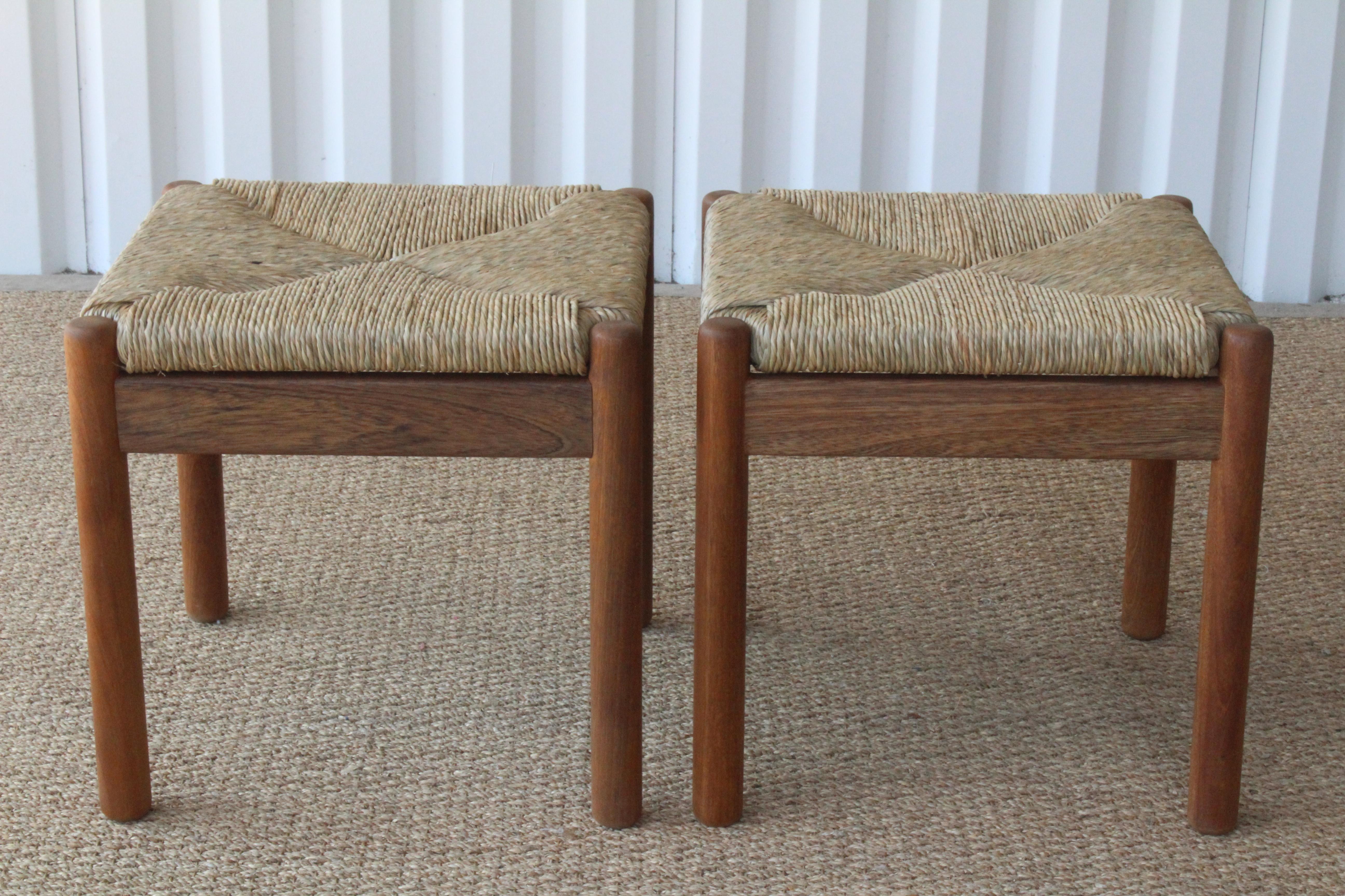 Pair of vintage 1960s Danish stools in walnut with newly woven rush seats. The walnut has been refinished in a natural oil stain. Rush is natural. Excellent condition. Sold as a pair.