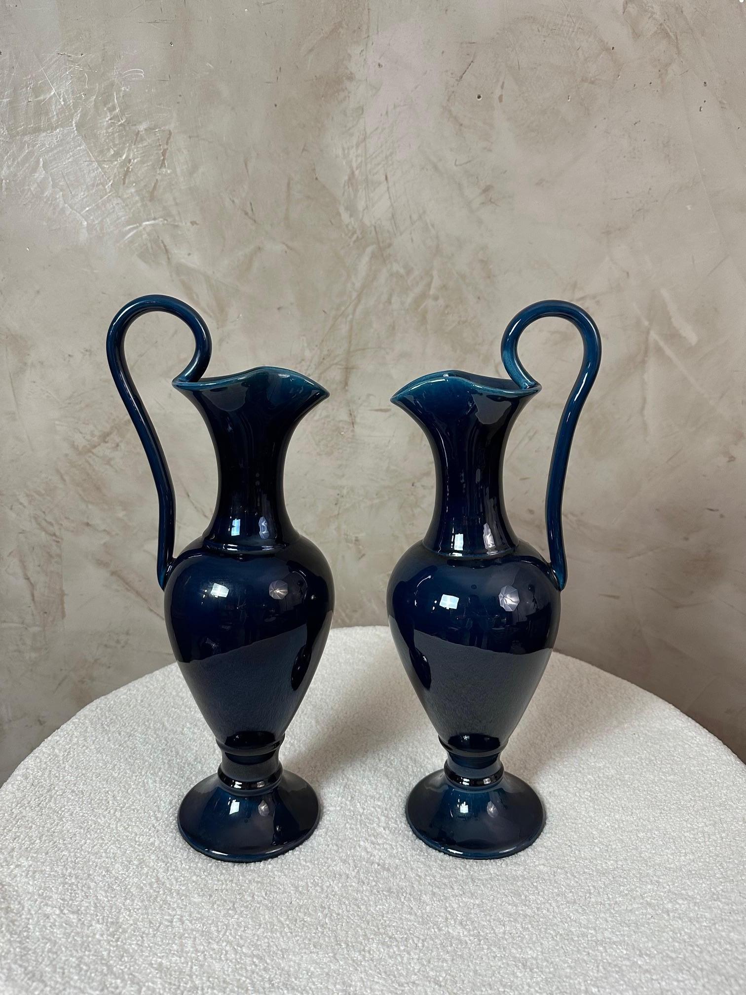 Paire d'aiguières en céramique émaillée bleu foncé, signées R. Bouly sur le dessous. Leur forme classique avec poignée haute et col évasé en fait un ensemble décoratif élégant, facile à mettre en valeur dans les intérieurs contemporains et