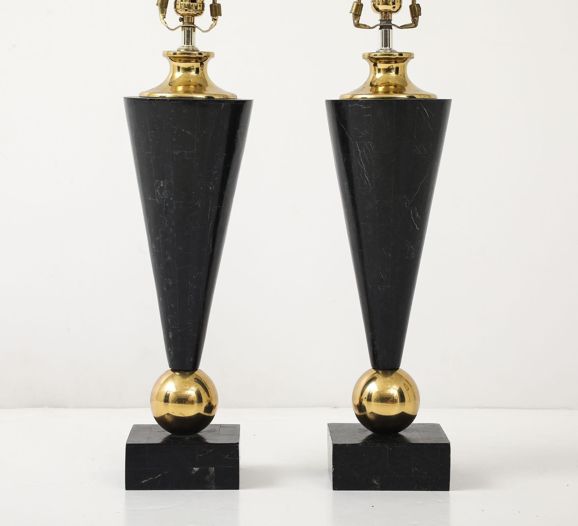 Discover a rare and striking pair of vintage table lamps that perfectly encapsulate the sophisticated aesthetic of the Mid-Century Modern era. These lamps are distinguished by their unique tessellated black marble bases, a captivating detail that