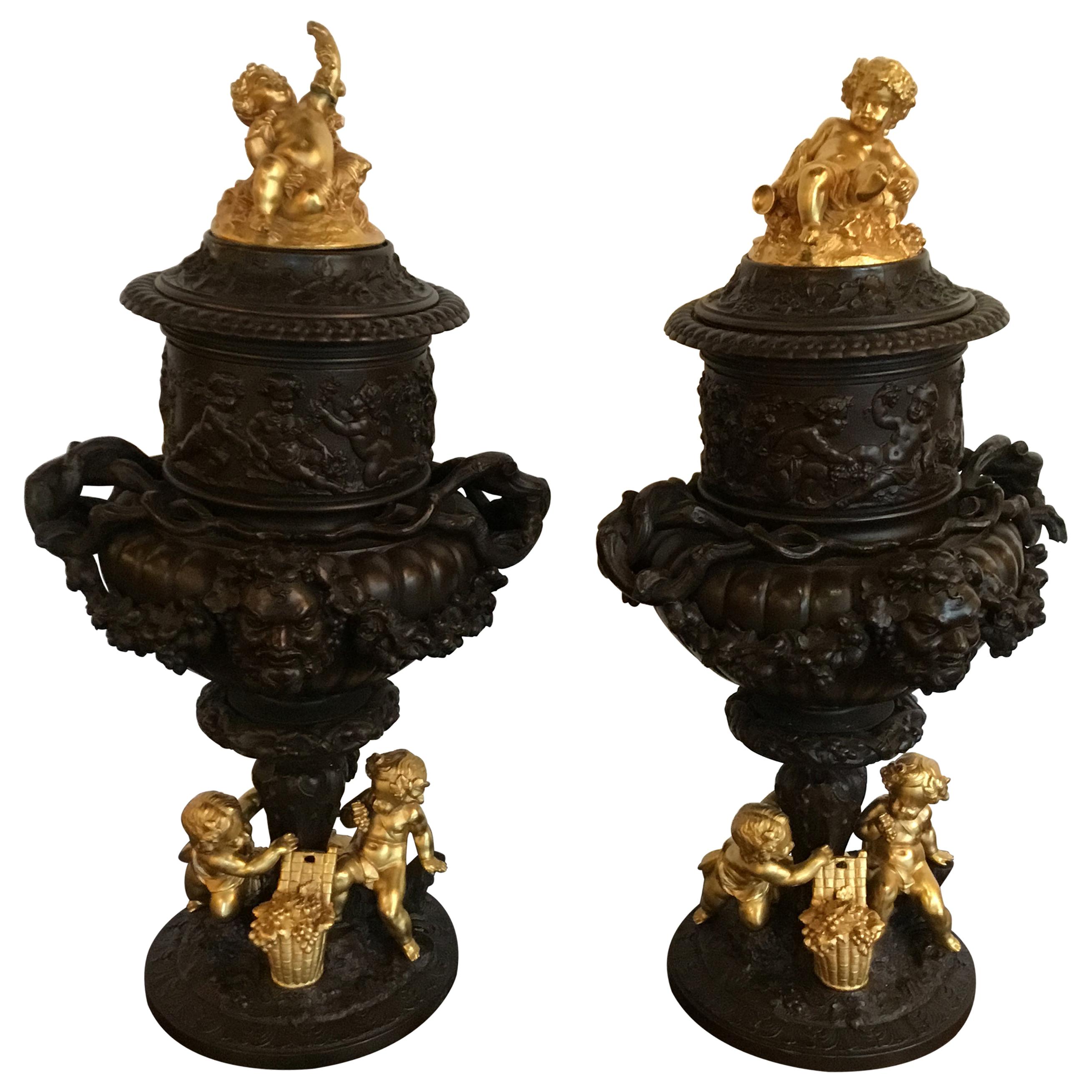 Pair of Dark Patinated Bronze Urns with Gilt Bronze Putti Caps, Baccanal Mask