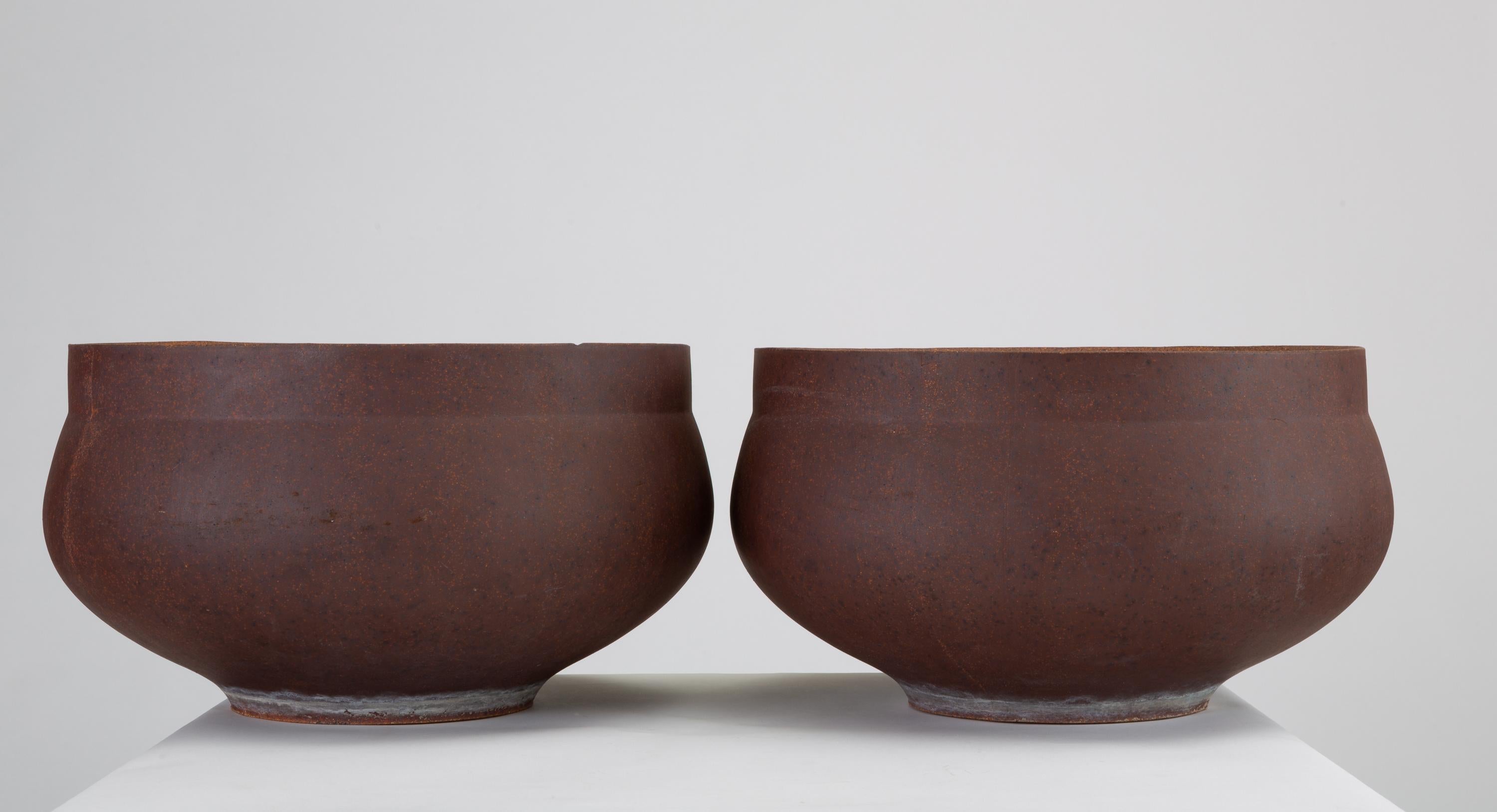 A pair of ceramic bowl planters from David Cressey's pro/artisan collection for Architectural Pottery. The unglazed planters have slightly bowed sides and a flattened lip. Listed price is for the pair of planters, though we have an additional single