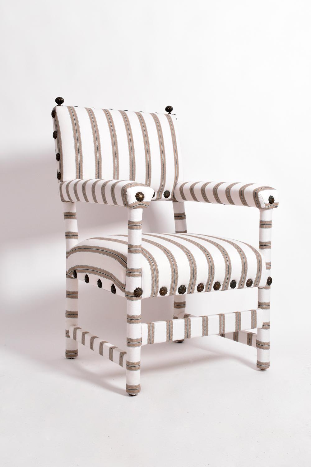 Pareja de sillones totalmente tapizados con tela de rayas y ornamentados con clavos decorativos. En el gusto de David Hicks. España, década de 1940. 