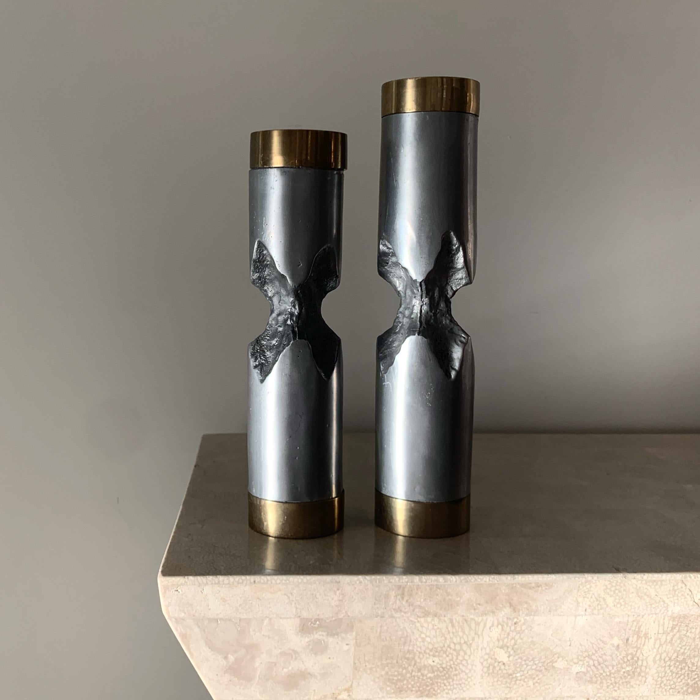 A stunning pair of Brutalist hand-crafted metallic and gilt candlesticks by David Marshall, 1970s. Aluminum and brass. Each hold a standard taper candle. Fabulous condition. Pick up in Los Angeles or delivery options available. 
Measures: Smaller: