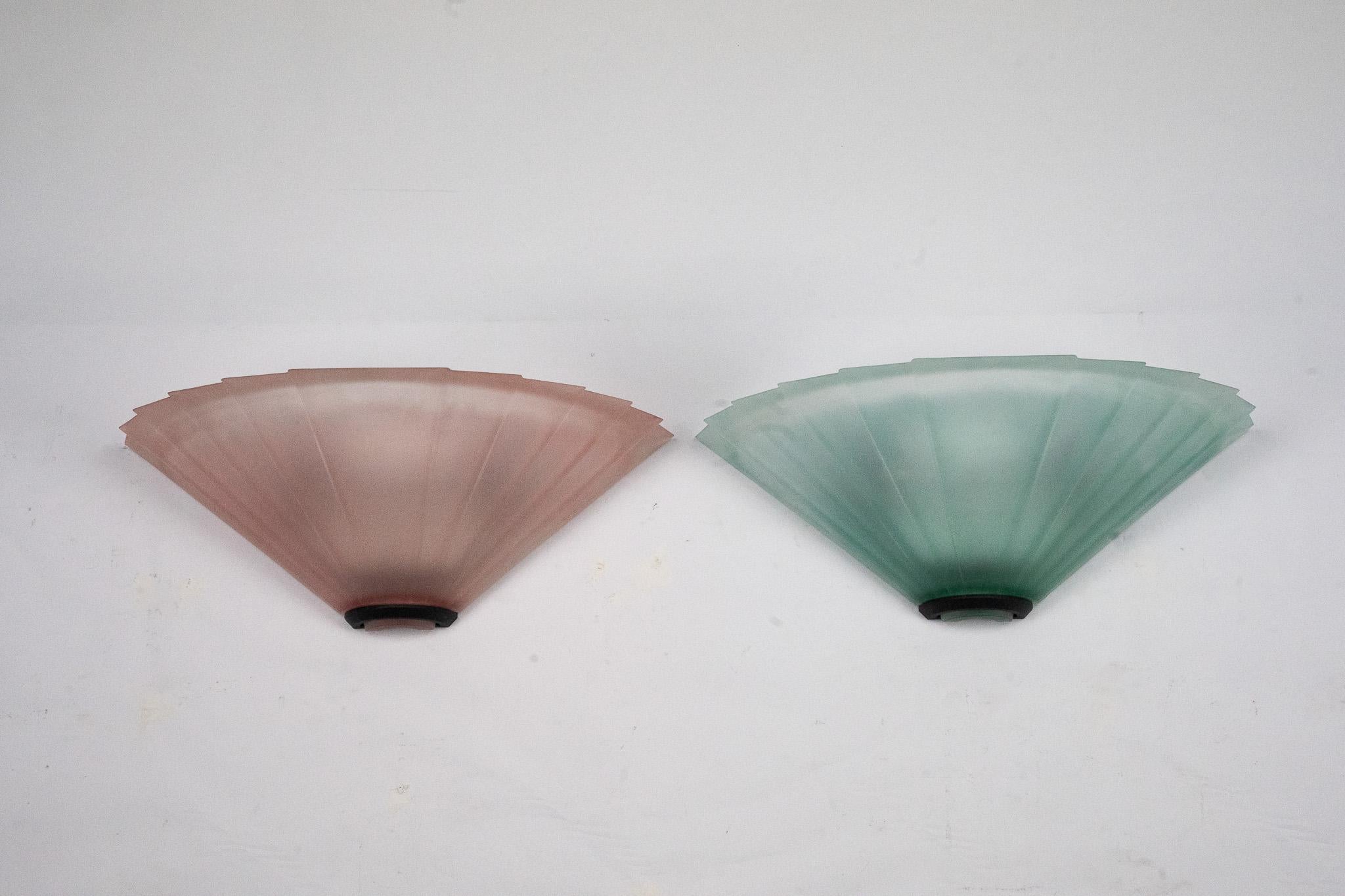 Elegant pair of wall sconces produced by De Majo in the 1980s. Each piece features a fan-shaped design in textured pink or green Murano glass, recalling Art Deco inspirations while reflecting the refined craftsmanship of Venetian glassmaking.
The