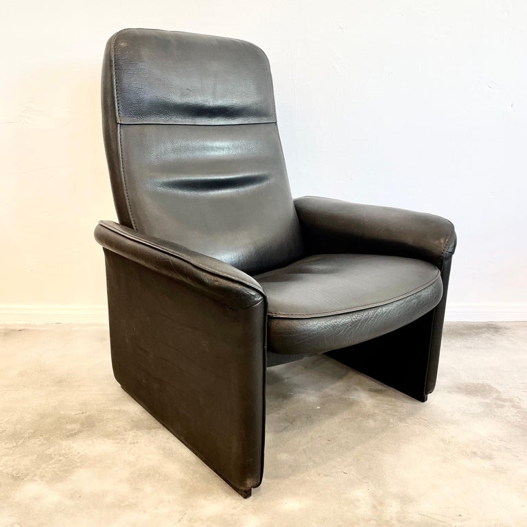Pair of executive lounge chairs by De Sede made in the 1970s, Switzerland. Chairs feature a reclining mechanism allowing you to recline the chairs almost flat if you choose. Extremely comfortable. These chairs feature a solid wooden frame and are