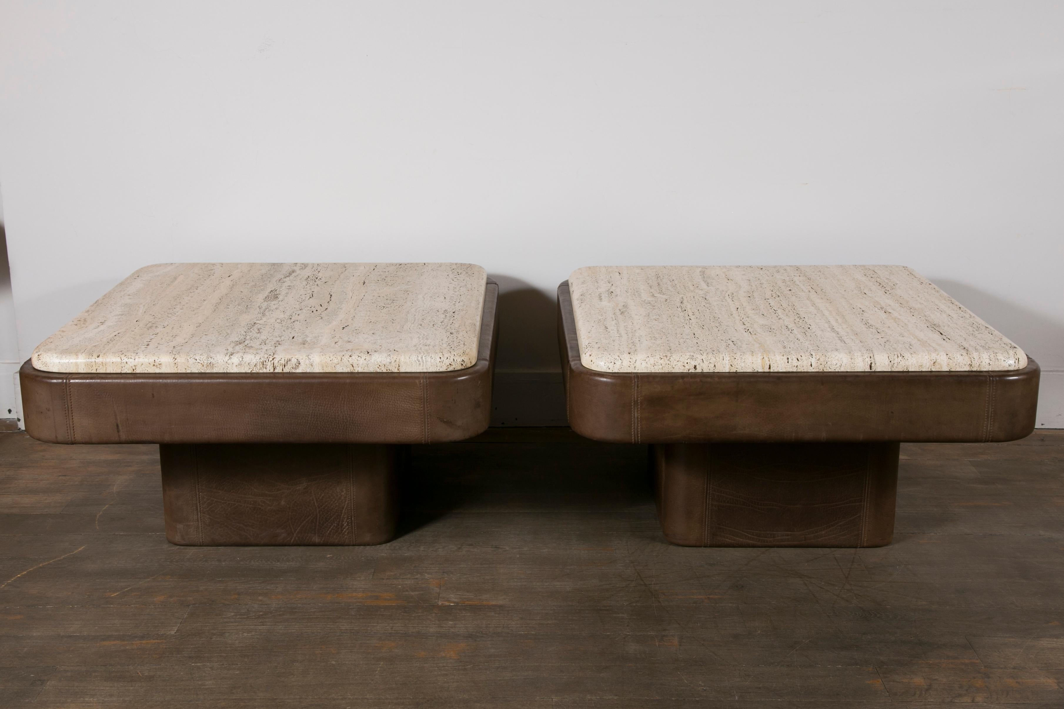 Pair of brown leather end tables with thick travertine tops
Edited by De Sede.
Switzerland, circa 1970.

Dimensions: 
Height 41 cm (16.1 in.)
Width 80 cm (31.5 in.)
Depth 80 cm (31.5 in.)

Travertine top 75 x 75 cm (29.5 x 29.5 in.).
 