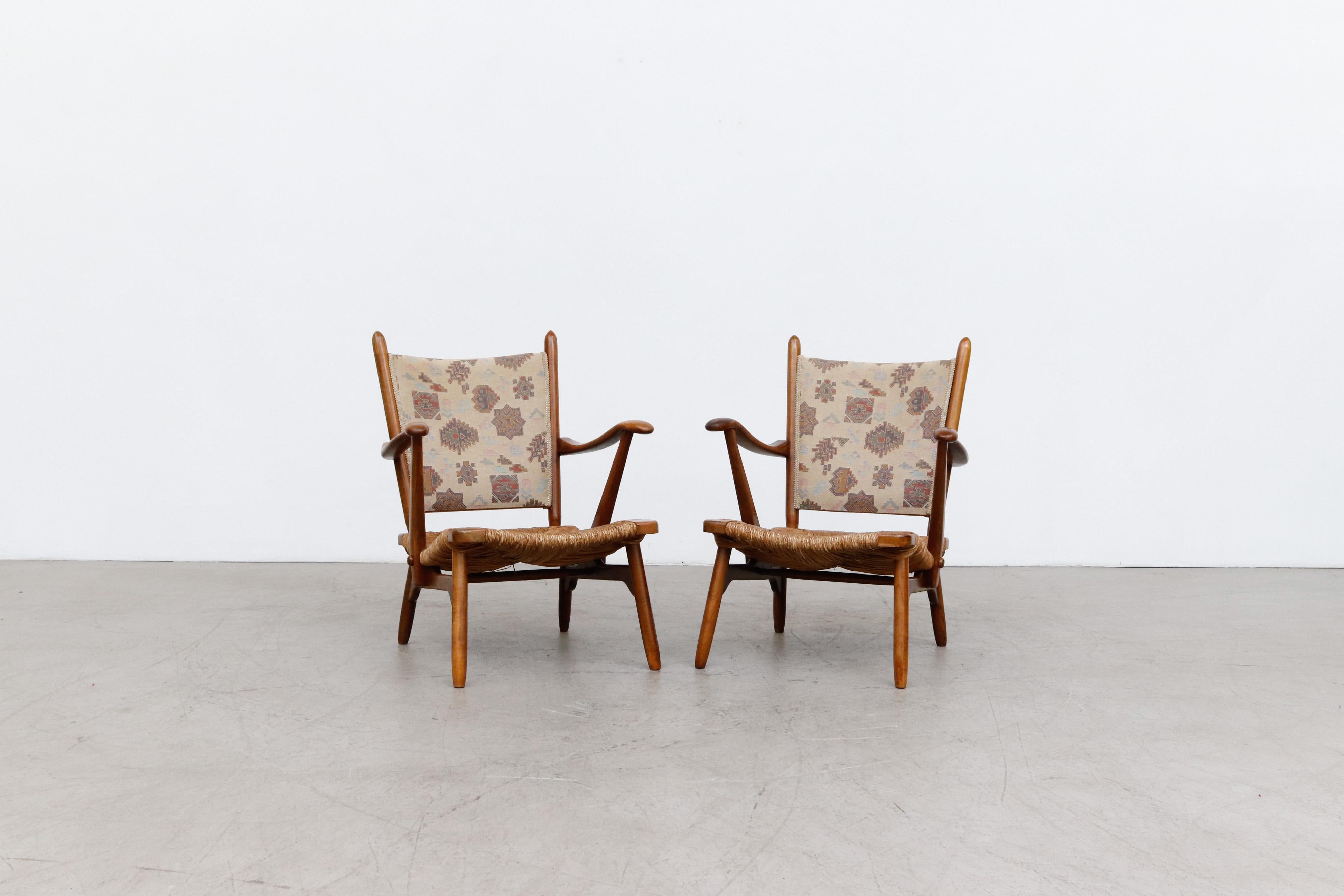 Pair of De Ster Gelderland upholstered lounge chairs with rush seats. Manufactured in the 1950s in the netherlands. Organically shaped armchairs with a hand woven rush seating. In original condition, wear consistent with its age and use.
