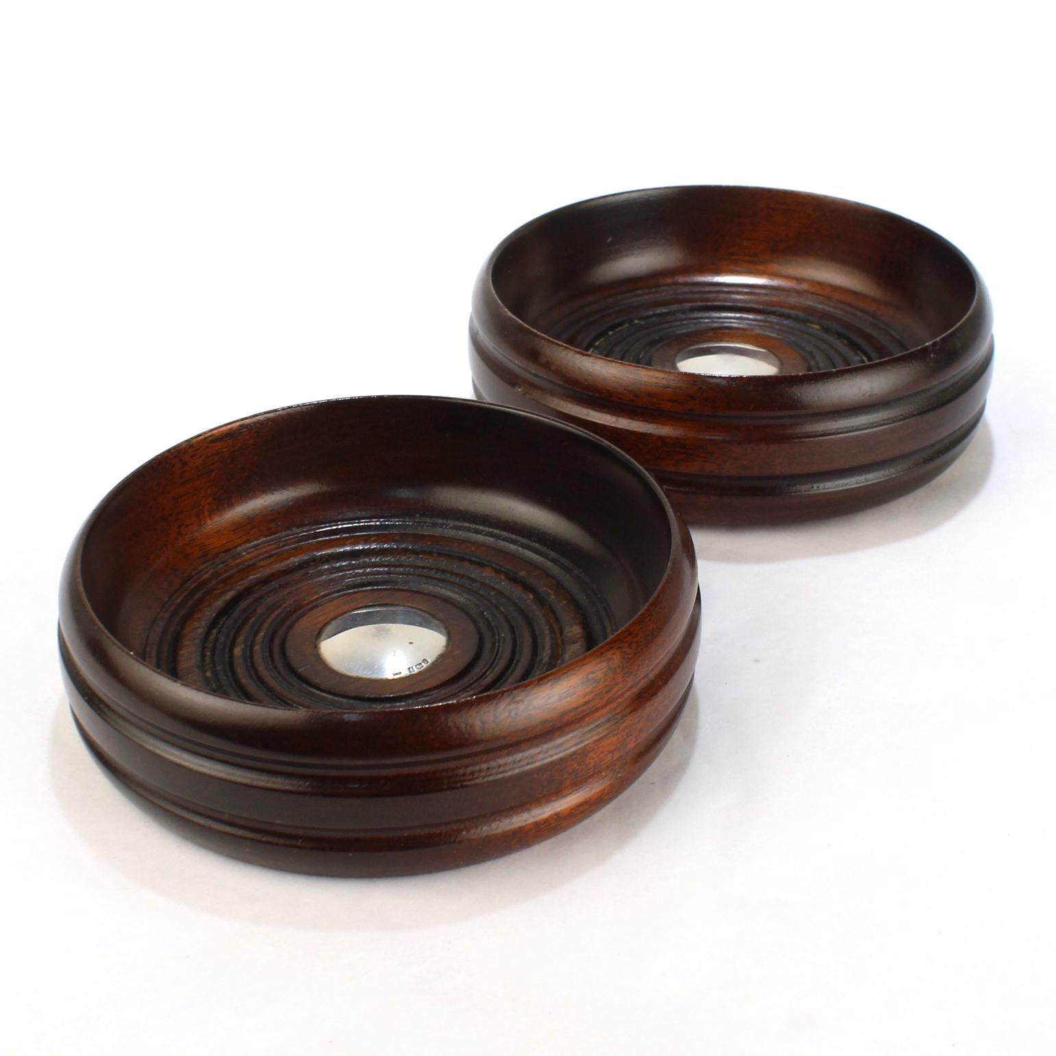 A fine pair of Edwardian style English wine coasters.

Comprised of turned wood (likely mahogany) and mounted with sterling silver buttons to the center. 

By Deakin & Francis of Birmingham. 

Simply a fine pair of coasters for the table!