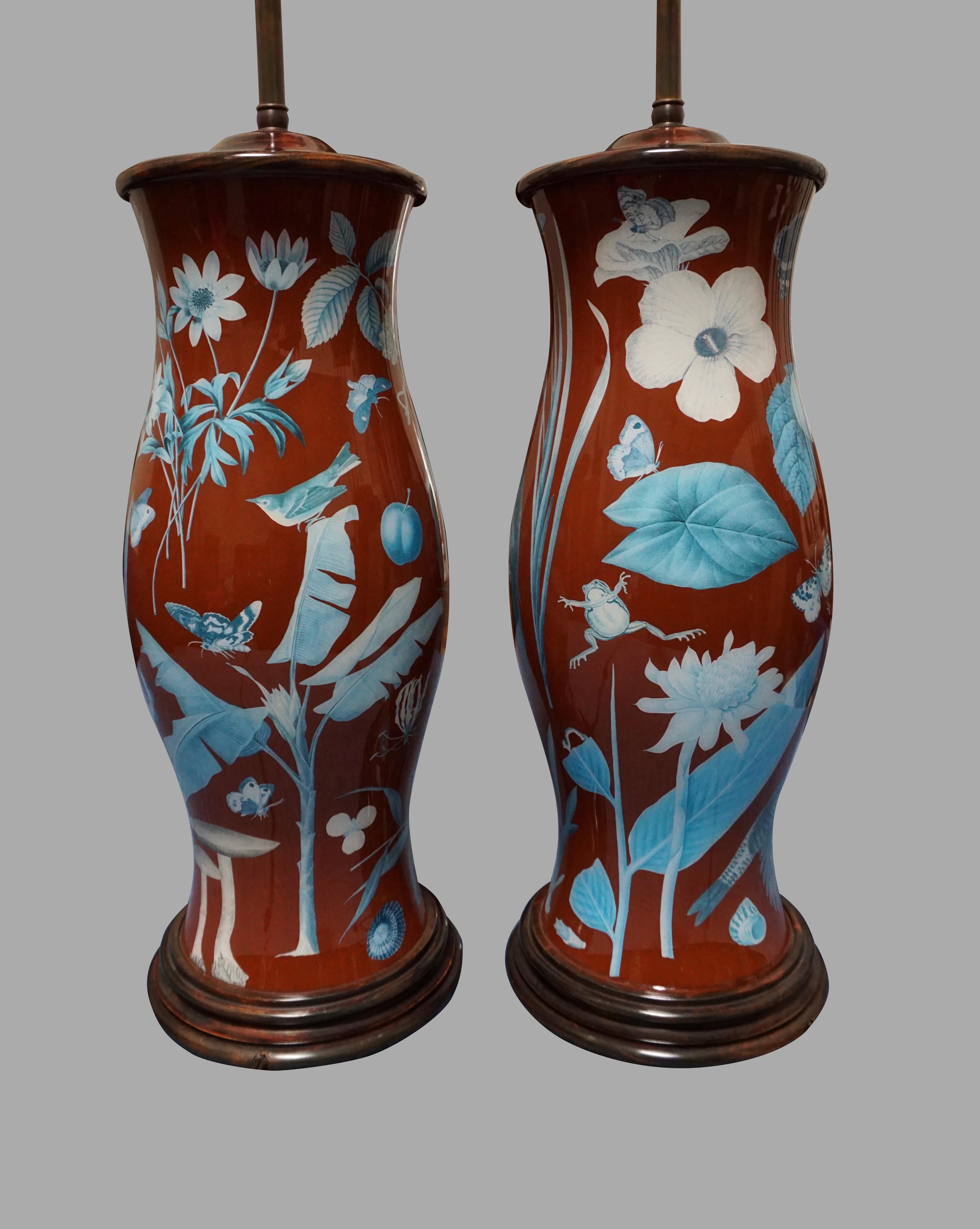 A highly decorative pair of decalcomania baluster form lamps decorated overall with exotic birds, frogs butterflies and plants in colors of red, orange, green and blue mounted with wooden bases and caps.
Wonderful design and substantial scale. No