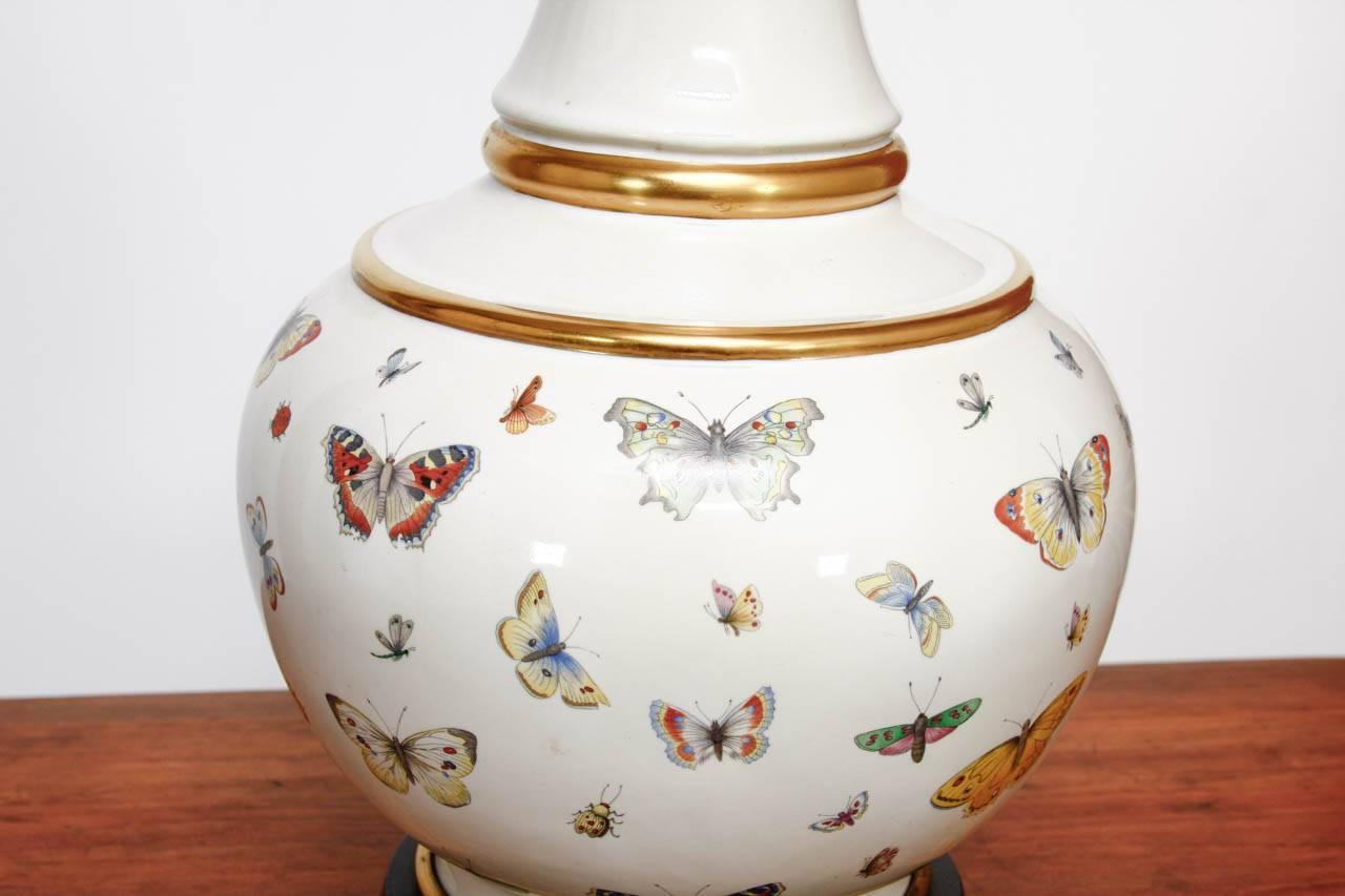 Marvelous pair of decalcomania style porcelain table lamps featuring butterfly specimens. Produced by designer Leonard Foss these porcelain vases have gilt accents and measure 15
