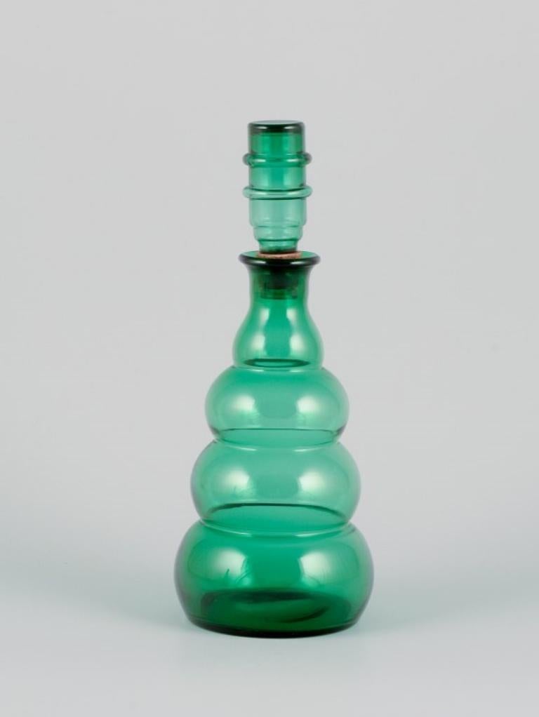 A pair of decanters in green art glass from a Swedish glassworks. 
Mouth-blown in Art Deco style.
Approximately from the 1930s.
In perfect condition.
Dimensions: D 9.5 cm x H 24.0 cm.