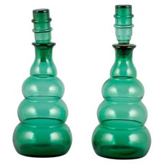 Pair of decanters in green art glass from a Swedish glassworks.