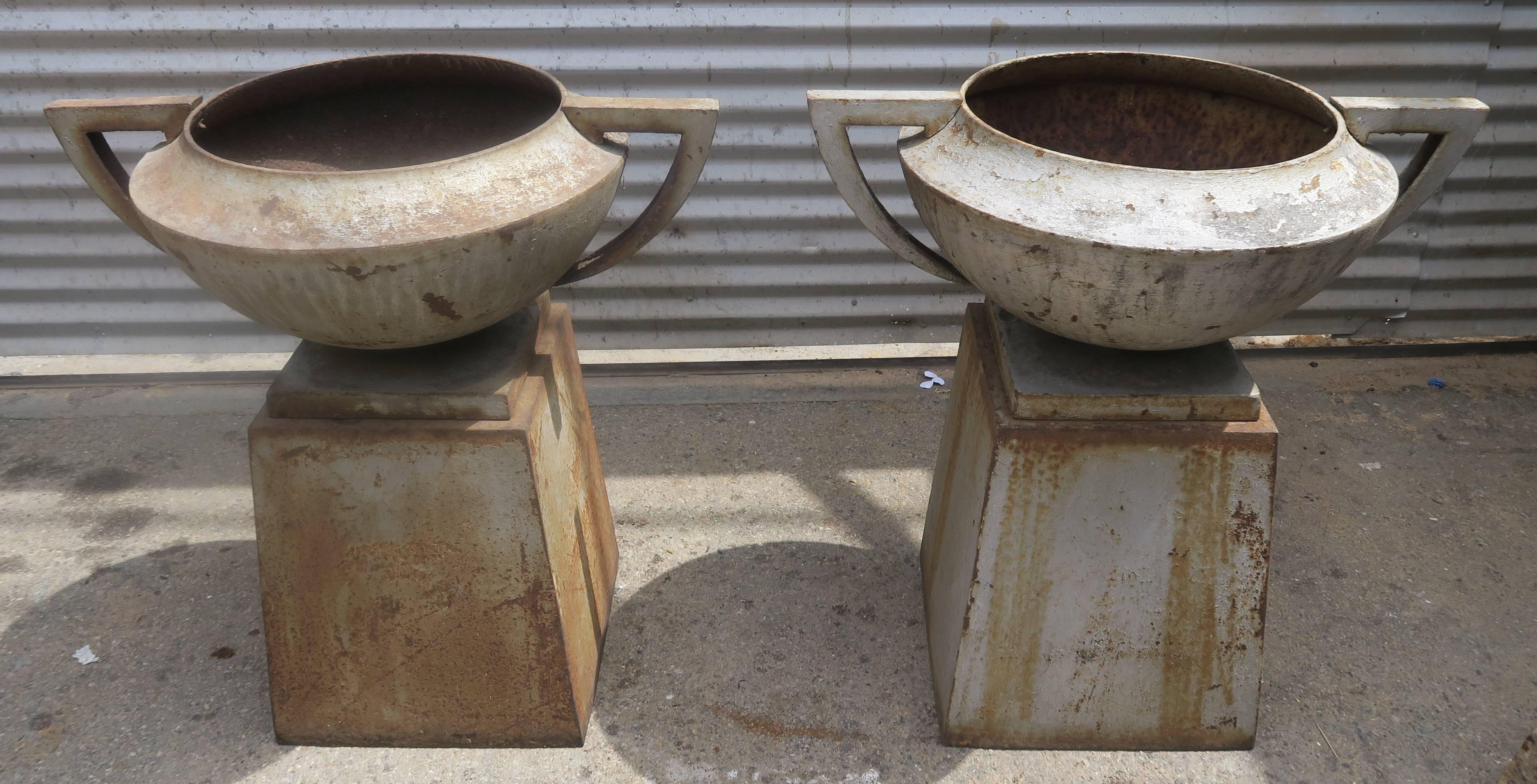 A matched PAIR of Deco heavy cast iron American planters with Grecian shaped urns sitting on matching bases.