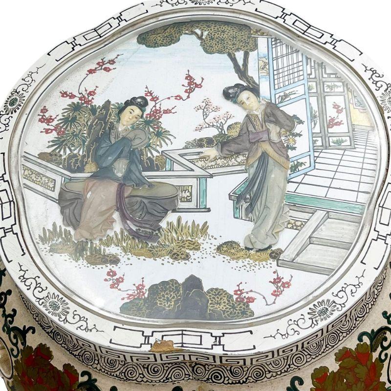 Paire de tabourets blancs en laque de Chine en forme de tambour ouvert, décorés d'un travail artistique complexe de volutes.  Les dessus encastrés de chaque tabouret présentent des images en miroir, en pierre dure sculptée, de deux personnages en