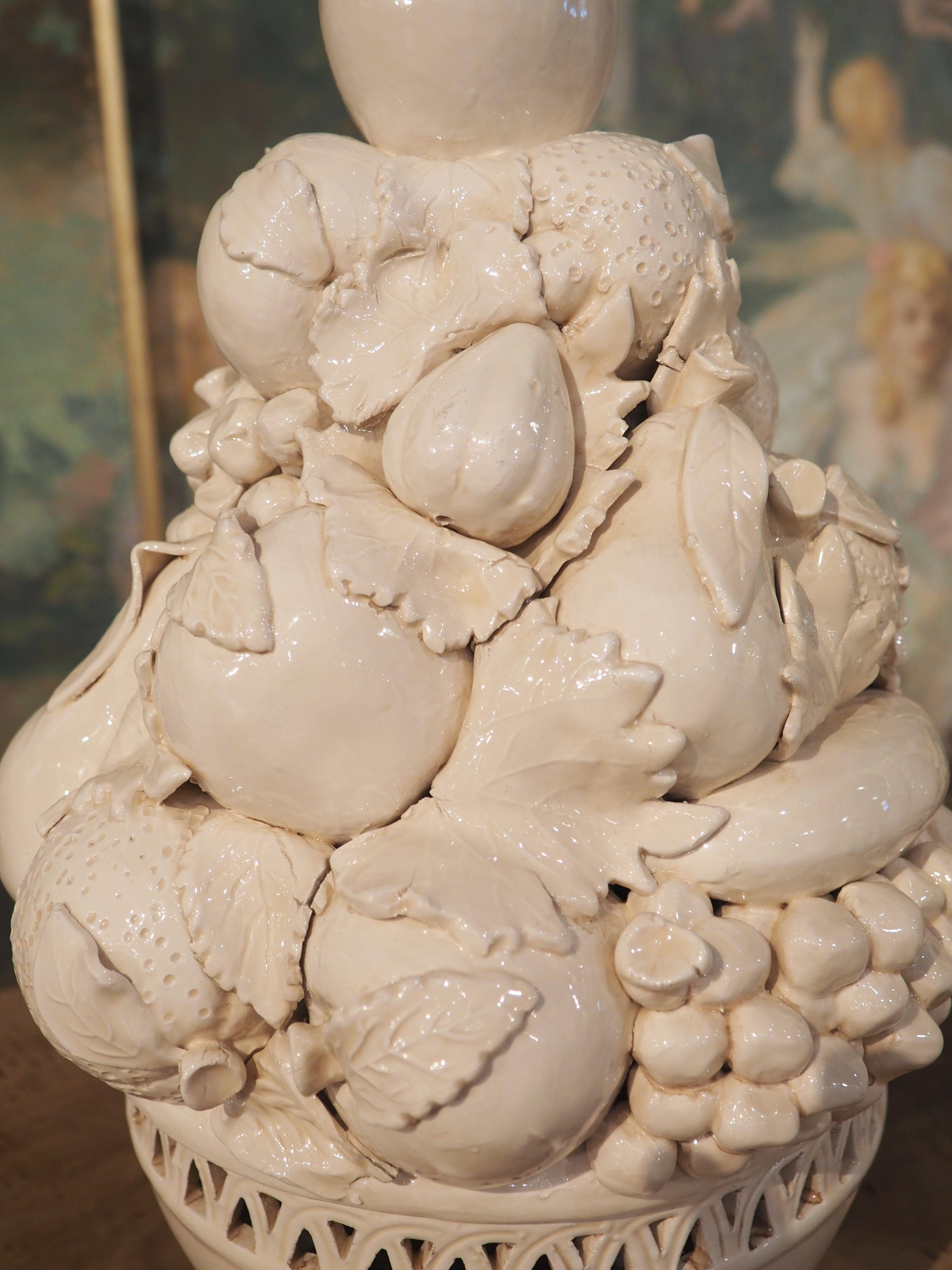 A very realistic rendering of a tower of fruit, this pair of creamware topiaries was produced in Italy during the 1960s. Creamware is a unique type of earthenware that is fired at lower temperatures (around 800 Celsius) than most other pottery, then