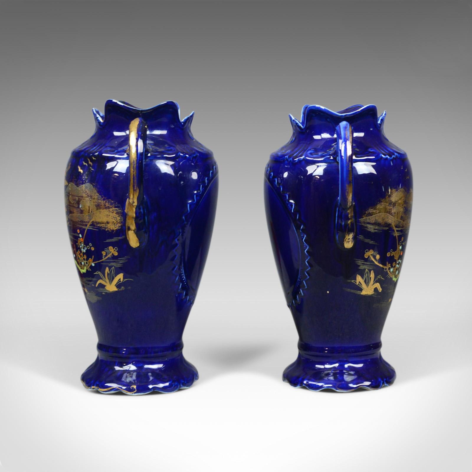 Il s'agit d'une paire de vases balustres décoratifs, des urnes en céramique de couleur or et bleue, estampillés England à la base, fin du 20e siècle.

Imposante paire de vases en céramique de qualité 
Profondément décoré en or sur un fond bleu