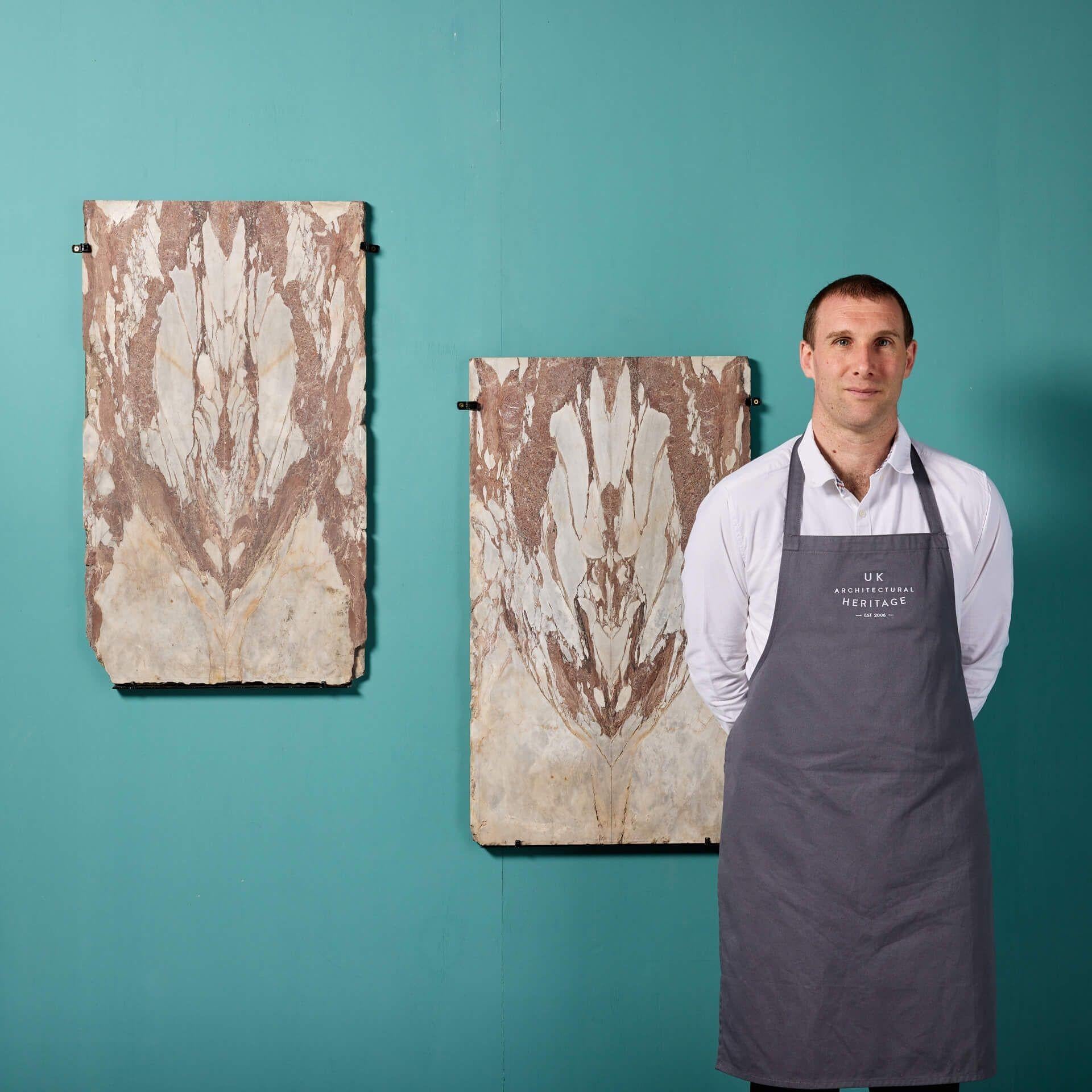 A striking large scale pair of bookmatched breccia marble wall decor panels. These natural cuts of marble are detailed with unique veins and markings throughout that make for spectacular pieces of abstract wall art. Though there is no subject, each