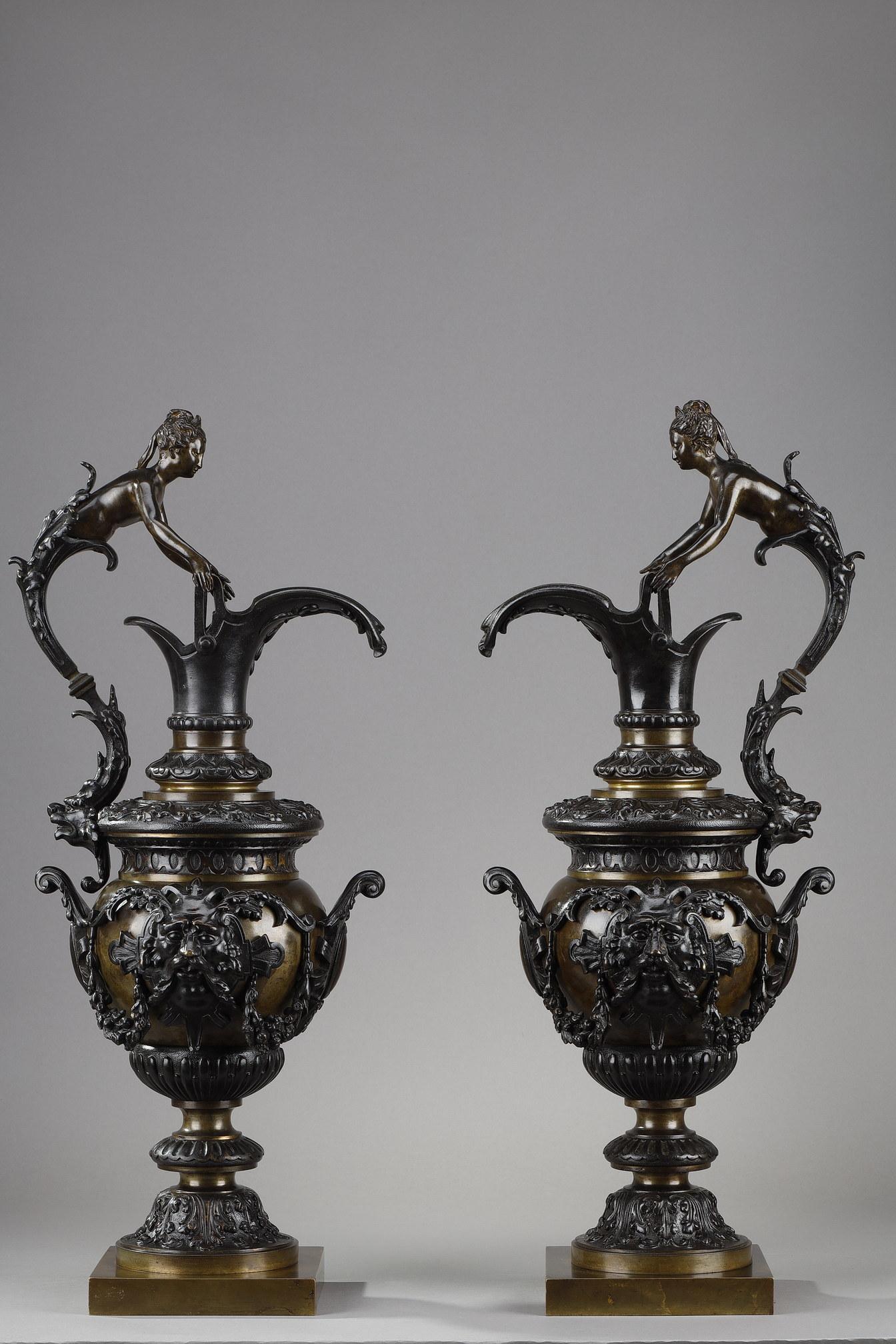 Pair of decorative ewers in bronze with two patinas in the Renaissance taste. The handles are in the form of busts of nude women wearing diadems emerging from acanthus leaves and ending with a lion's head. The body is decorated with masks,