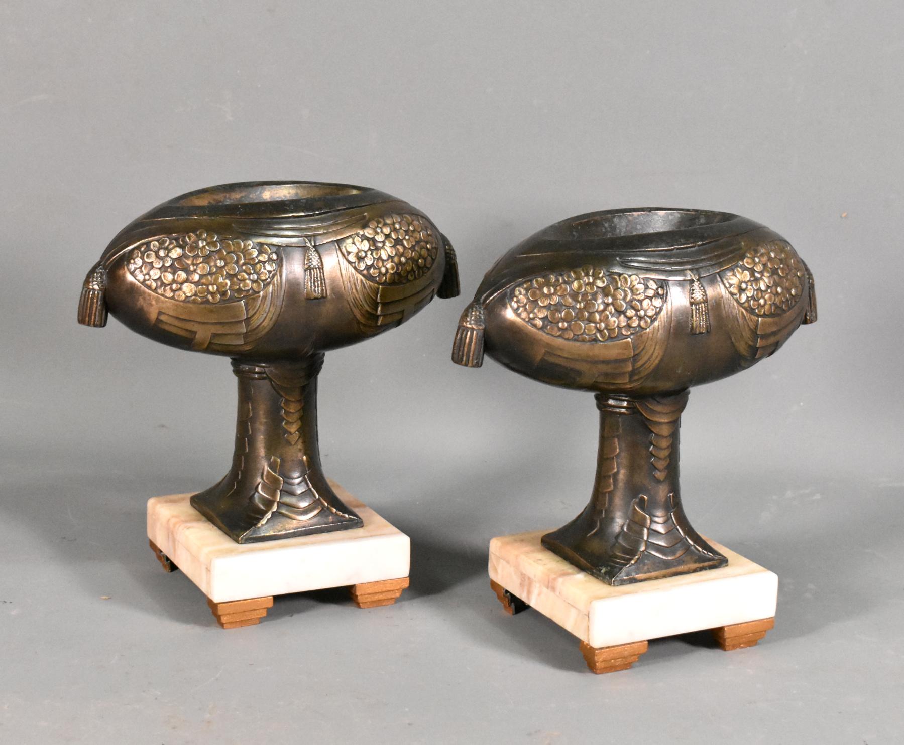 Pair of Decorative French Art Deco Garniture 

This unusual pair of garniture is decorated with floral motifs and swags of the Art Deco period. 

The garniture is of a good size with a dished bowl at the top. 

They stand on variegated marble