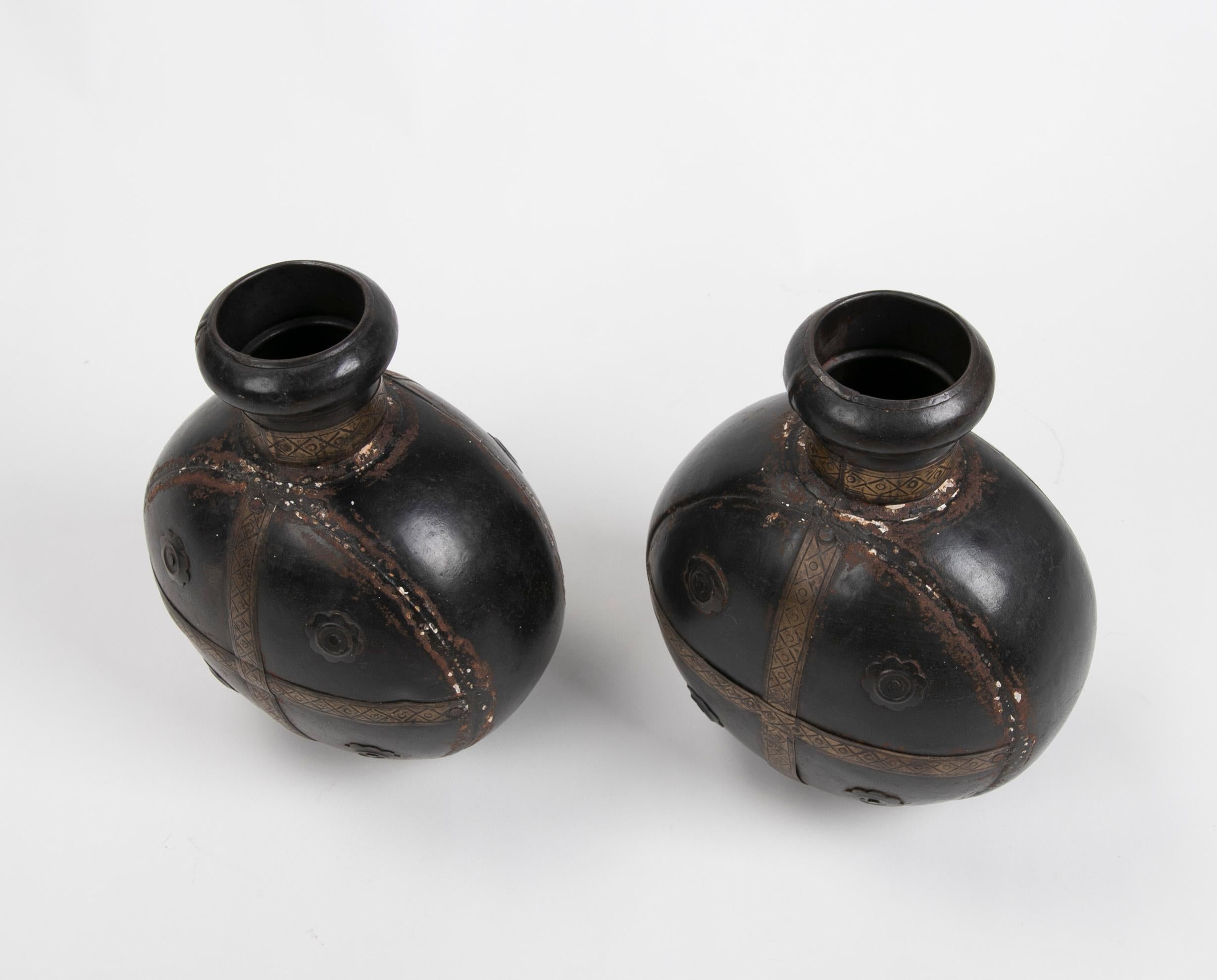 Pair of decorative metal bottles with decoration.