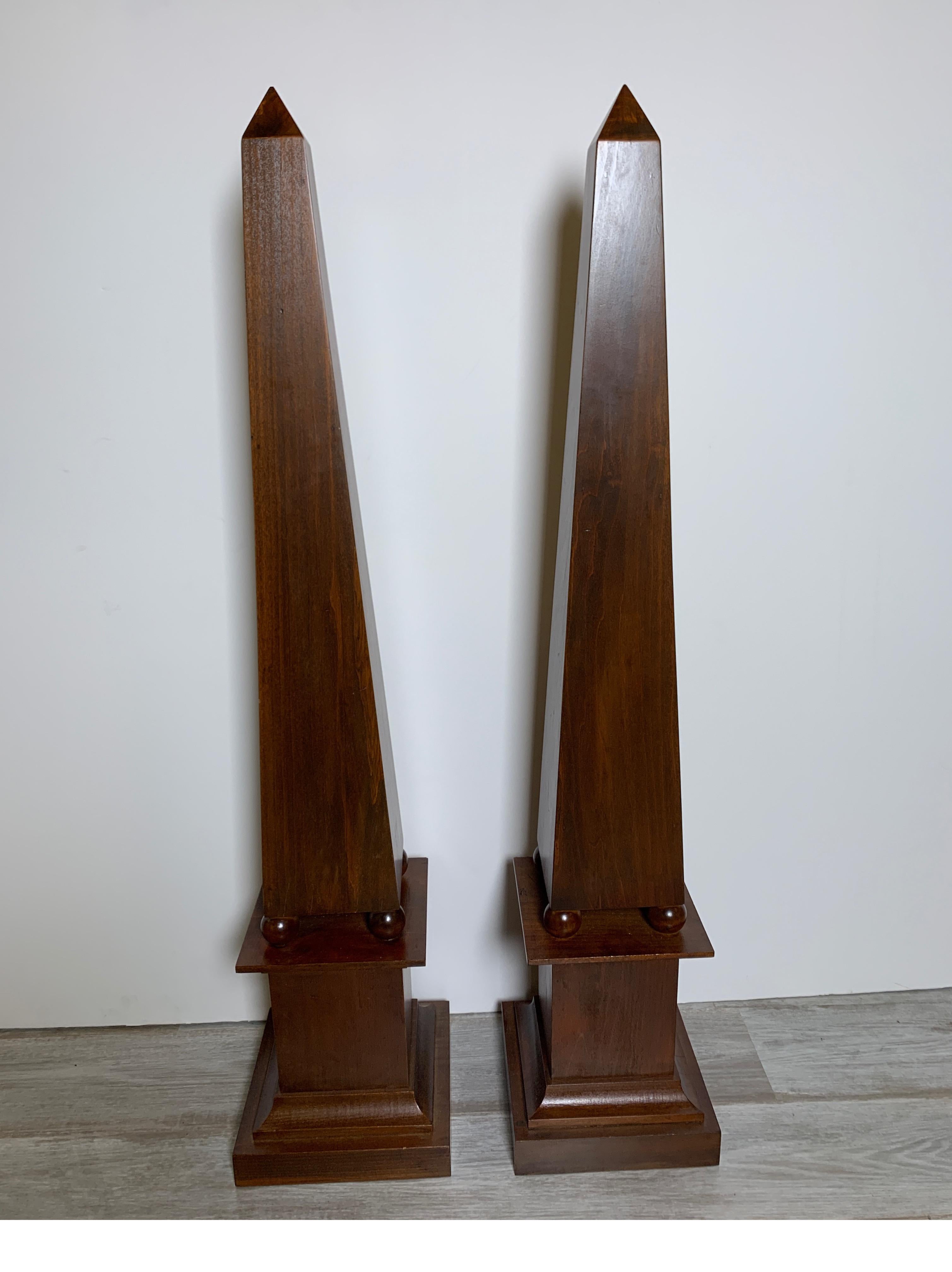 A Classic pair of 42 inch tall mahogany finish obelisks. The elegant pair in a warm rich wood finish.