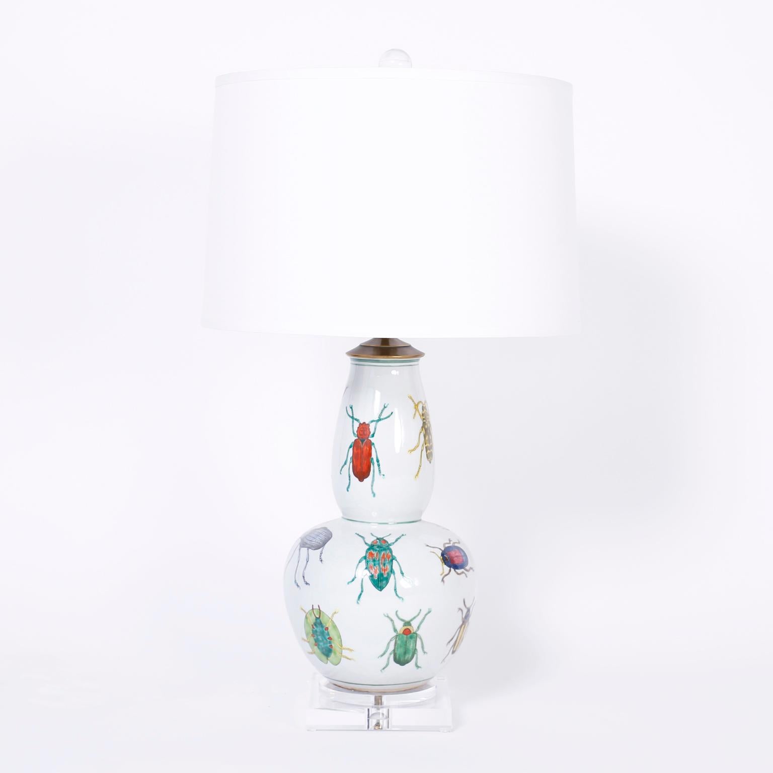 Chic pair of double gourd table lamps with reverse decoupage exotic beetle species against a white background and presented on double plinth Lucite bases.
