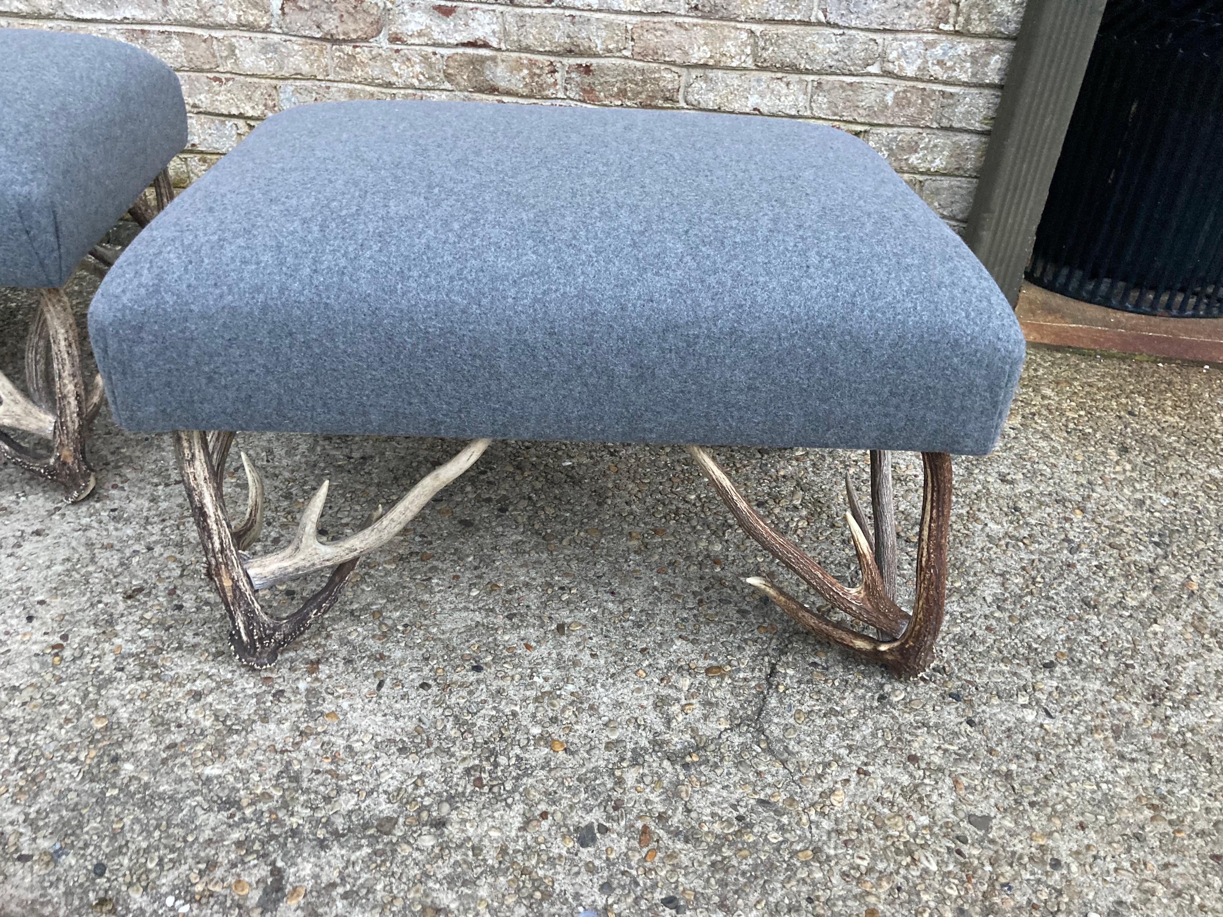 Pair of deer antler based ottomans or benches newly reupholstered in gray flannel.
