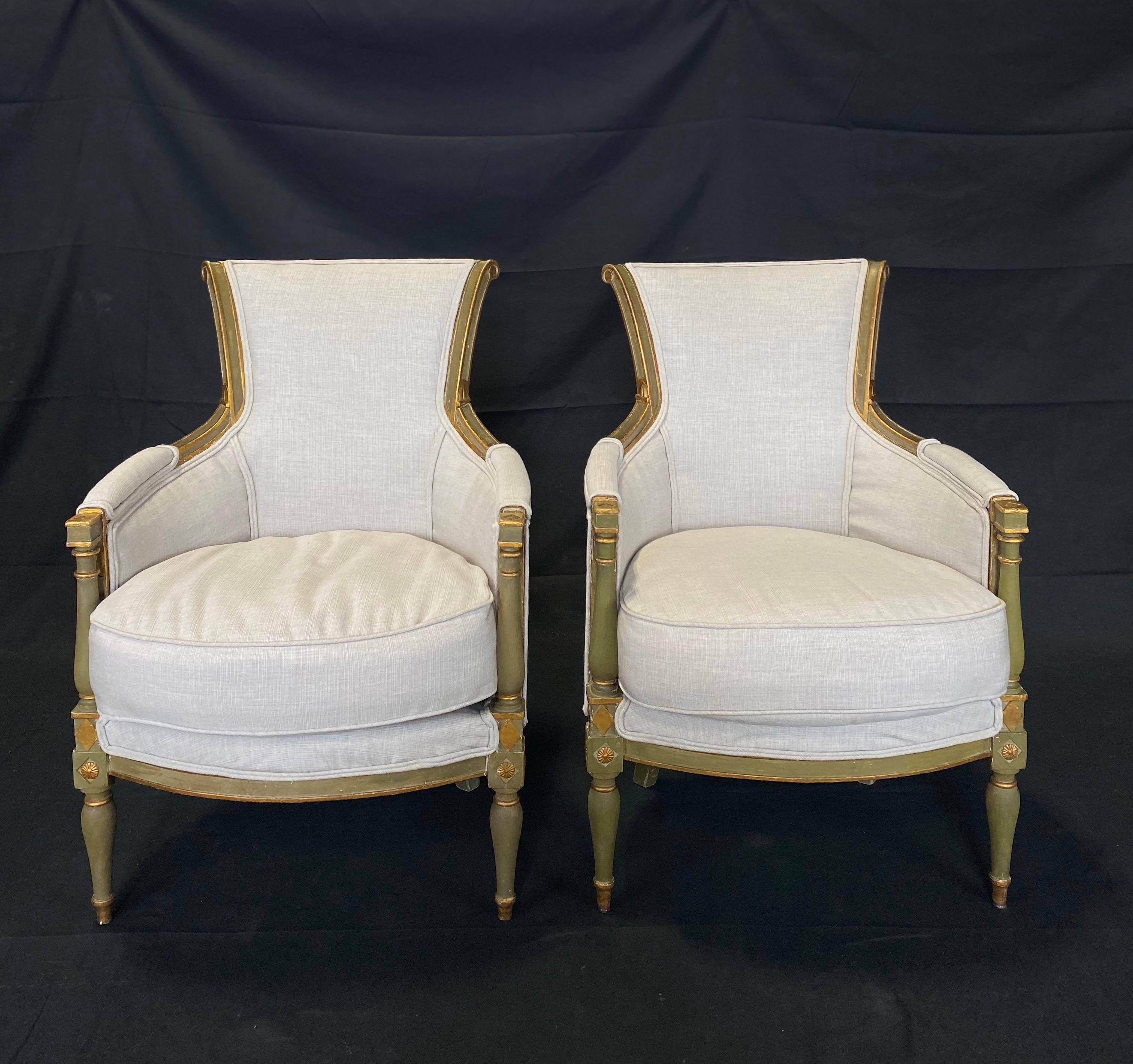 Pair of 19th century Louis XVI neoclassical French bergères or armchairs with restored original olive and gold gilt paint. Made during the Louis XVI period in France. Channeled legs and armrests. Beautiful carvings in back and frieze. New upholstery