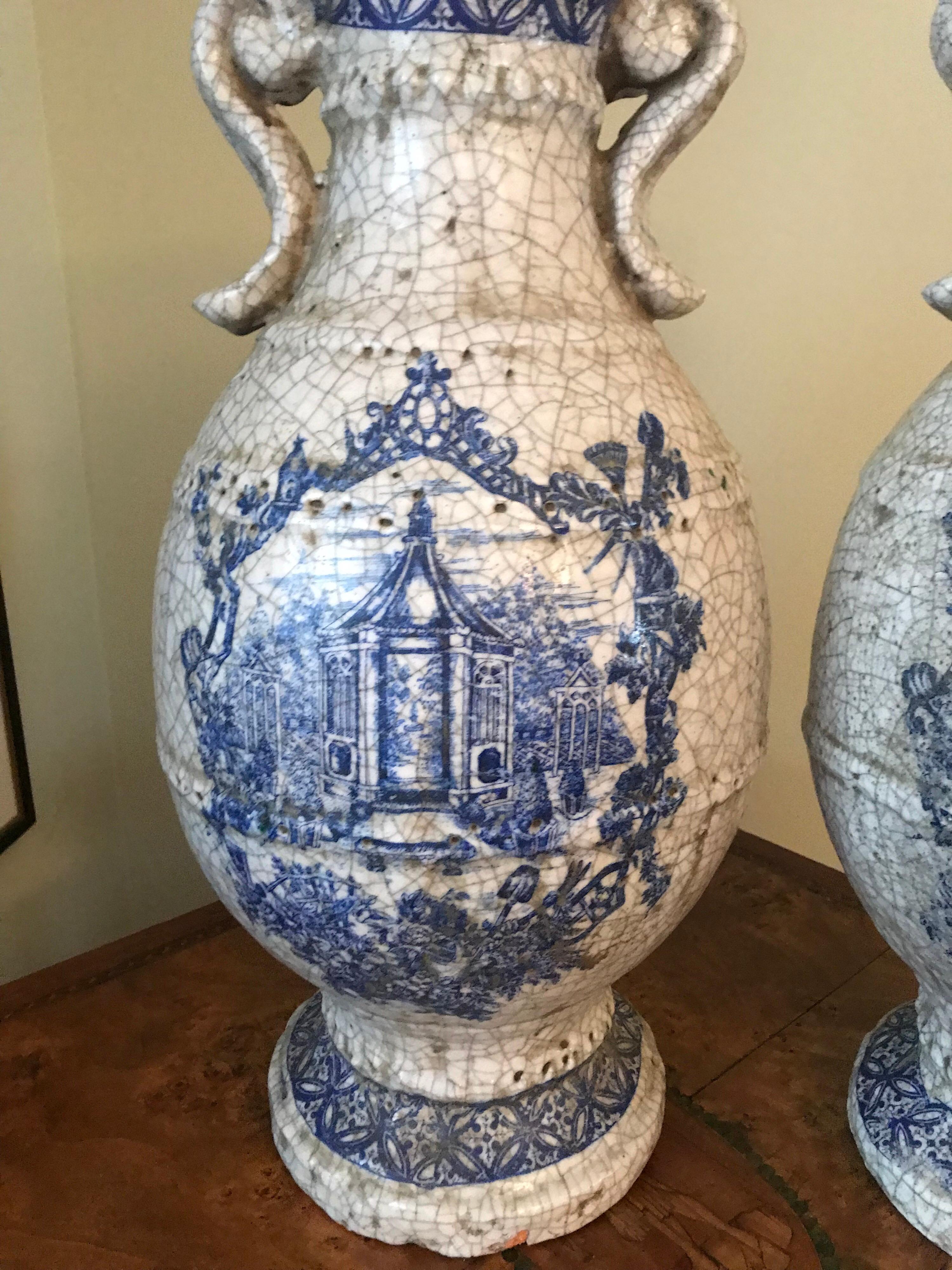 Large and impressive pair of earthenware blue transfer urns or vessels. Wonderful intentional patina and natural glaze marks. Blue transfer images on both sides.