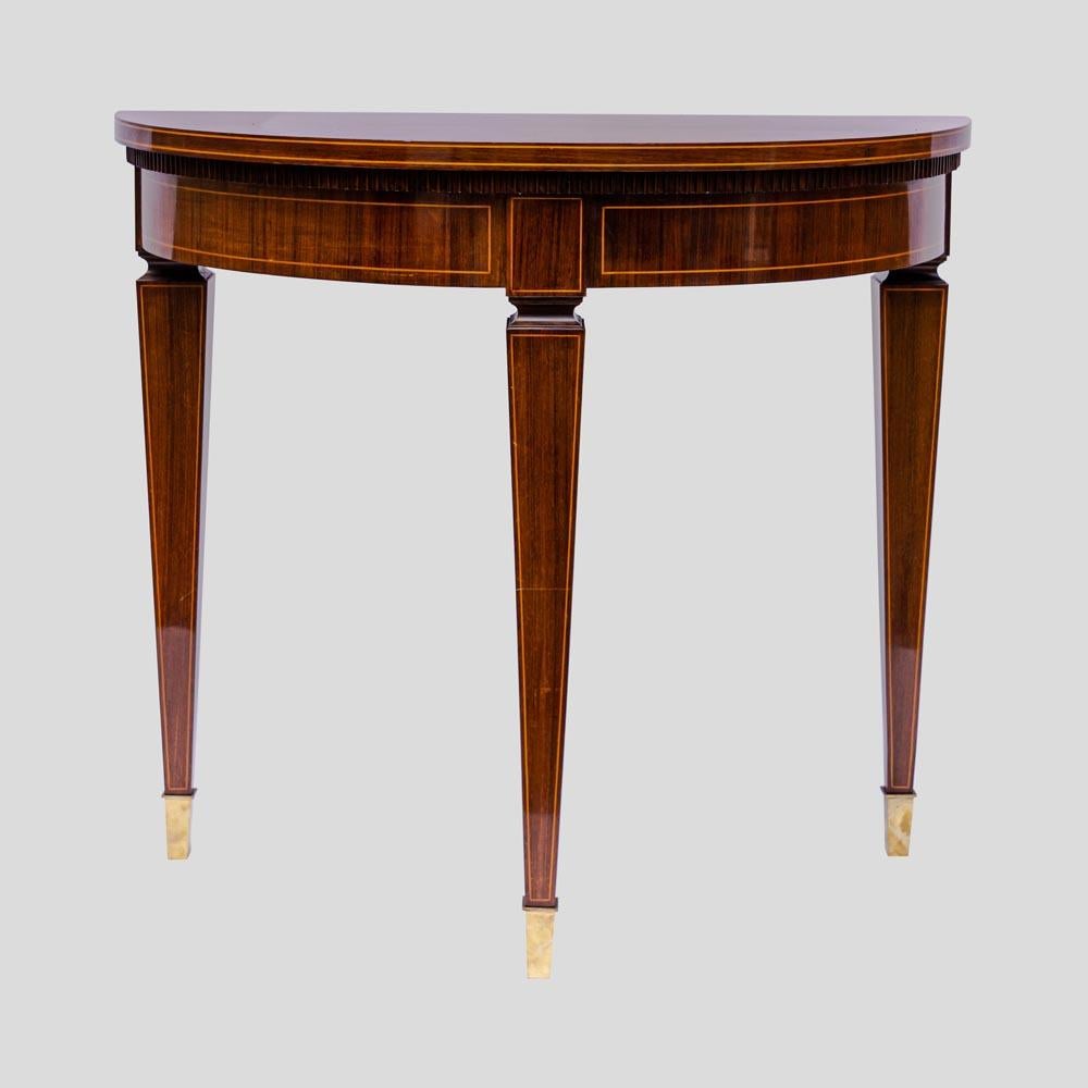 Early 1950s Pair of Demi Lune console tables, French polish Mahogany wood laminate  structure with tapered legs and feet with brass decoration. Protective glass top included. When placed back to back it becomes a round table. Italian design