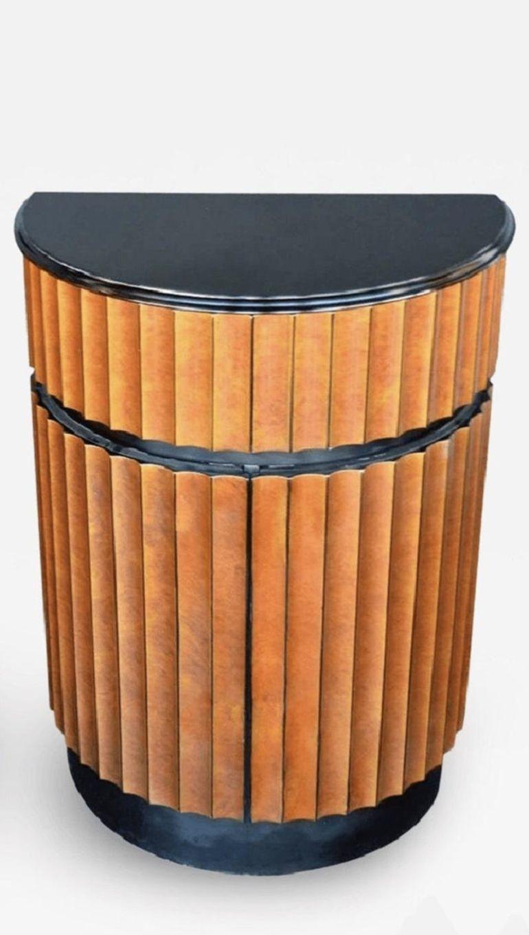 Elegante coppia di comodini demilune, ciascuno finemente realizzato negli Stati Uniti d'America negli anni '70 con dettagli in legno smussato e un sofisticato frontale con finitura finta. Le carrozzerie sono verniciate in un'elegante lacca nera che