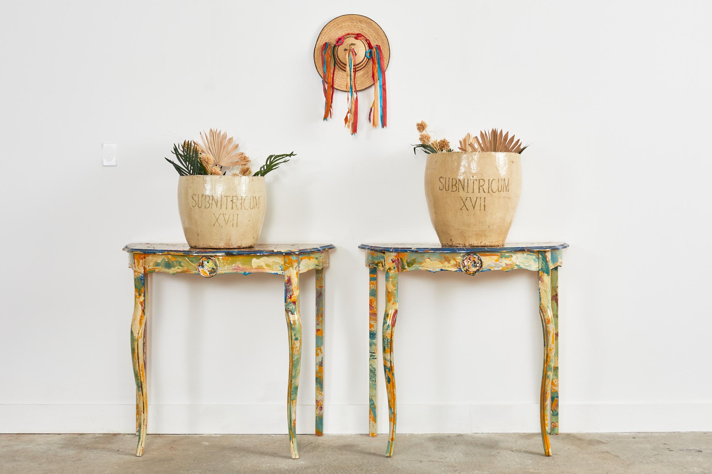 Fantastic pair of pine demi-lune console tables that form a dramatic center table painted by artist Ira Yeager (American 1938-2022). The tables are crafted from pine with a scalloped top and an ogee edge. The top has an abstract variegated design