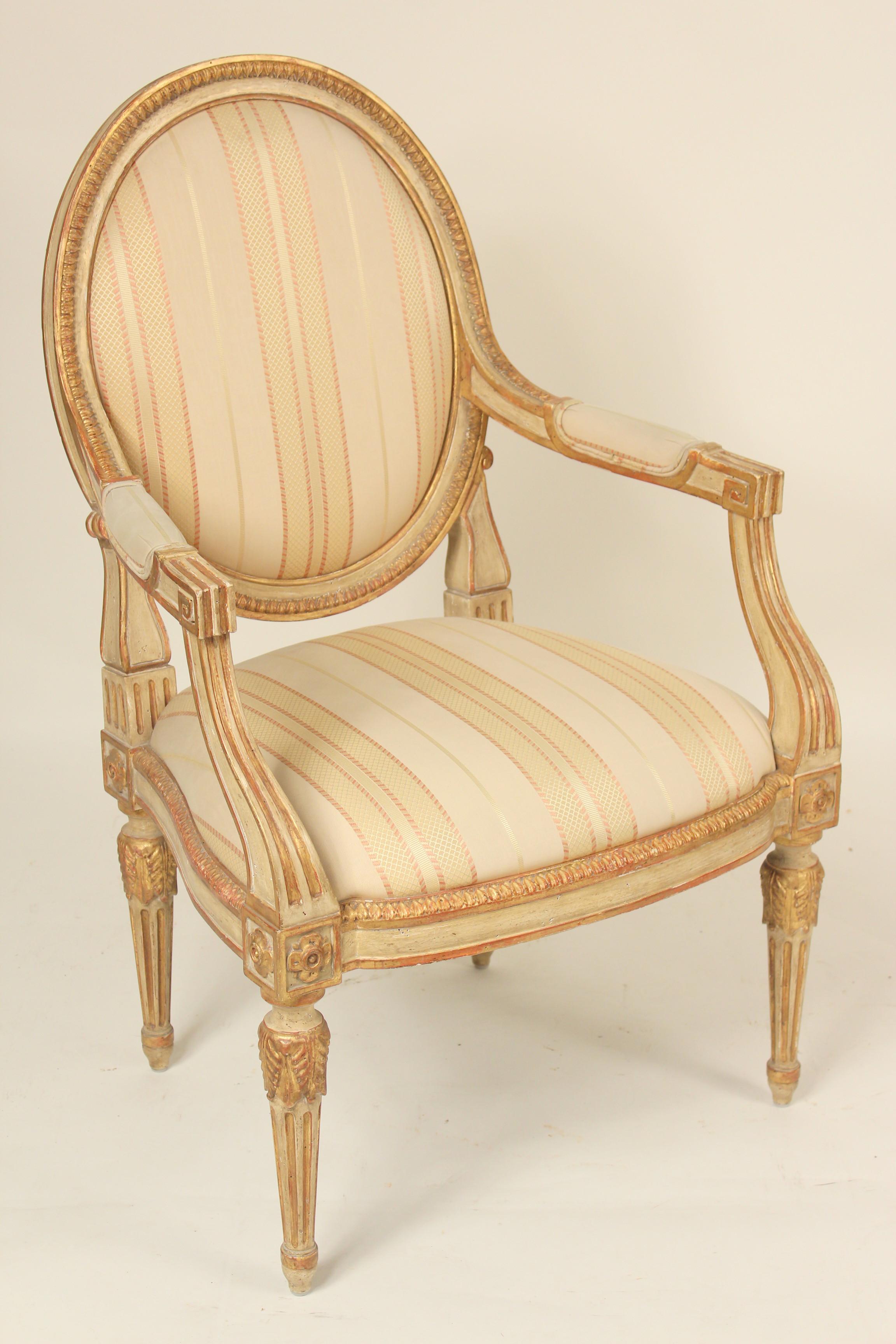 Pair of Dennis & Leen Louis XVI style painted and partial gilt armchairs, circa 1990-2000. These chairs have excellent quality gilded and painted surfaces and imitation worm holes.
