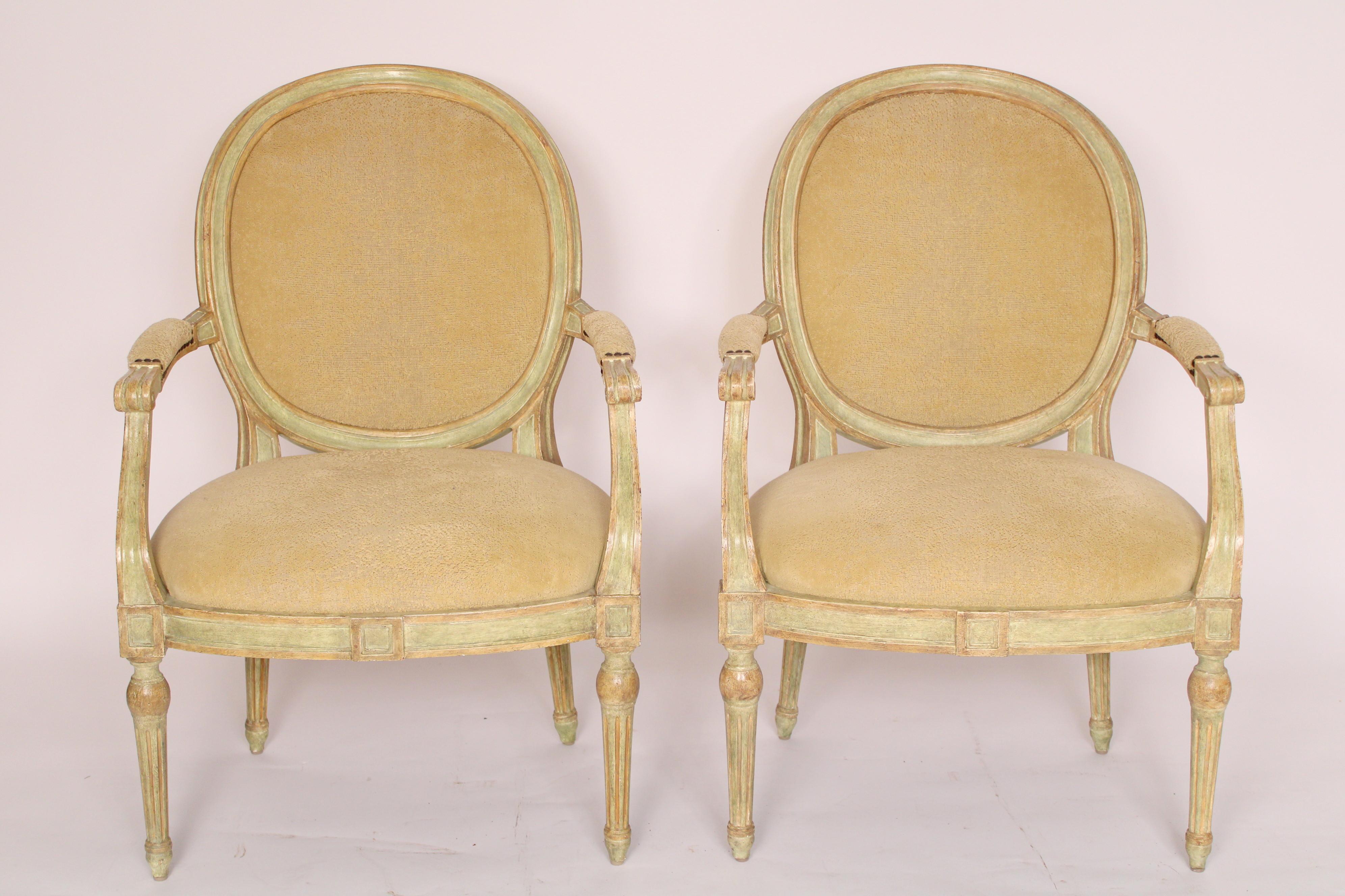 Paire de fauteuils italiens de style néoclassique peints en vert, fabriqués par Dennis and Leen, vers le début du 21e siècle. La face arrière des dossiers est recouverte d'un cuir très souple. Les dimensions du siège sont approximativement de 22,5